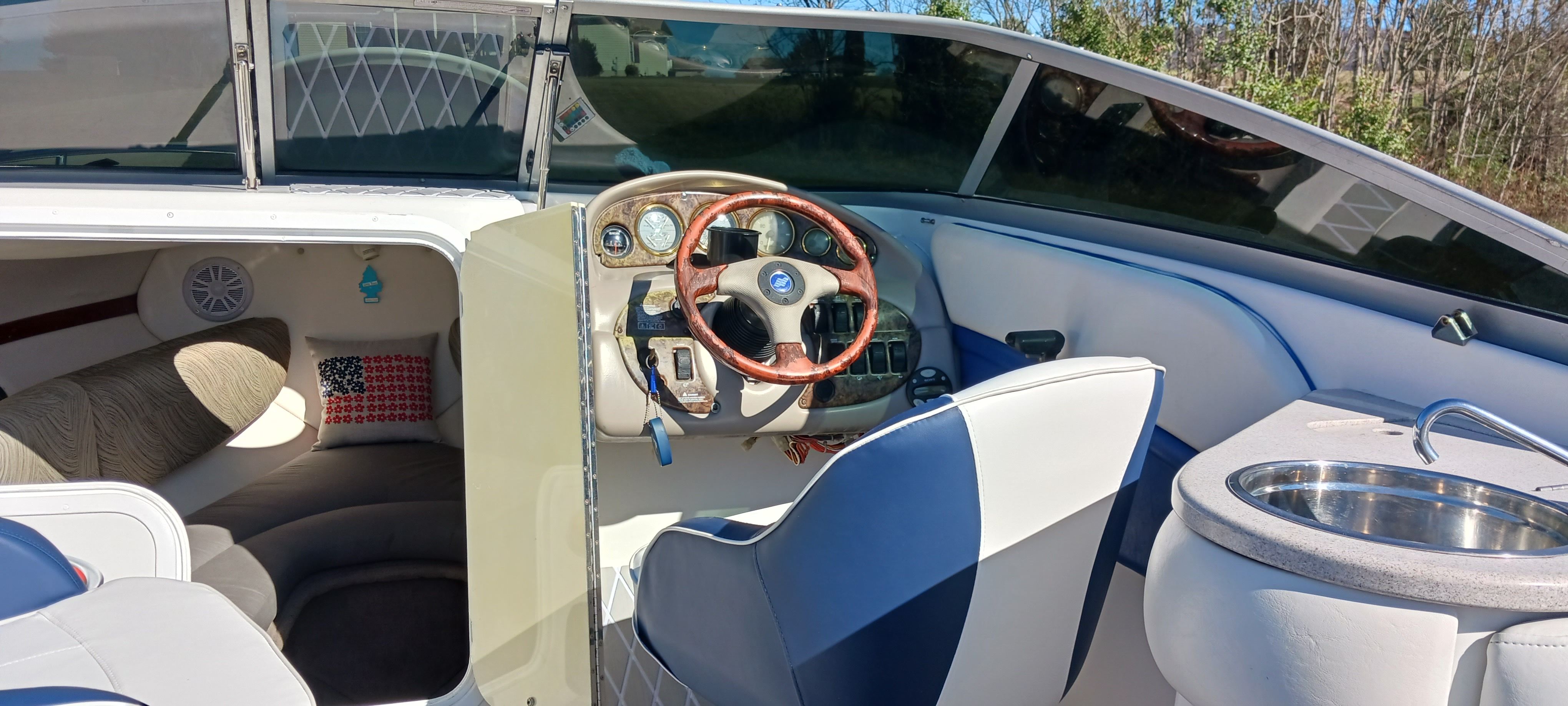 2003 Four Winns 205 Sundowner boat interior with steering wheel, seating, and sink.