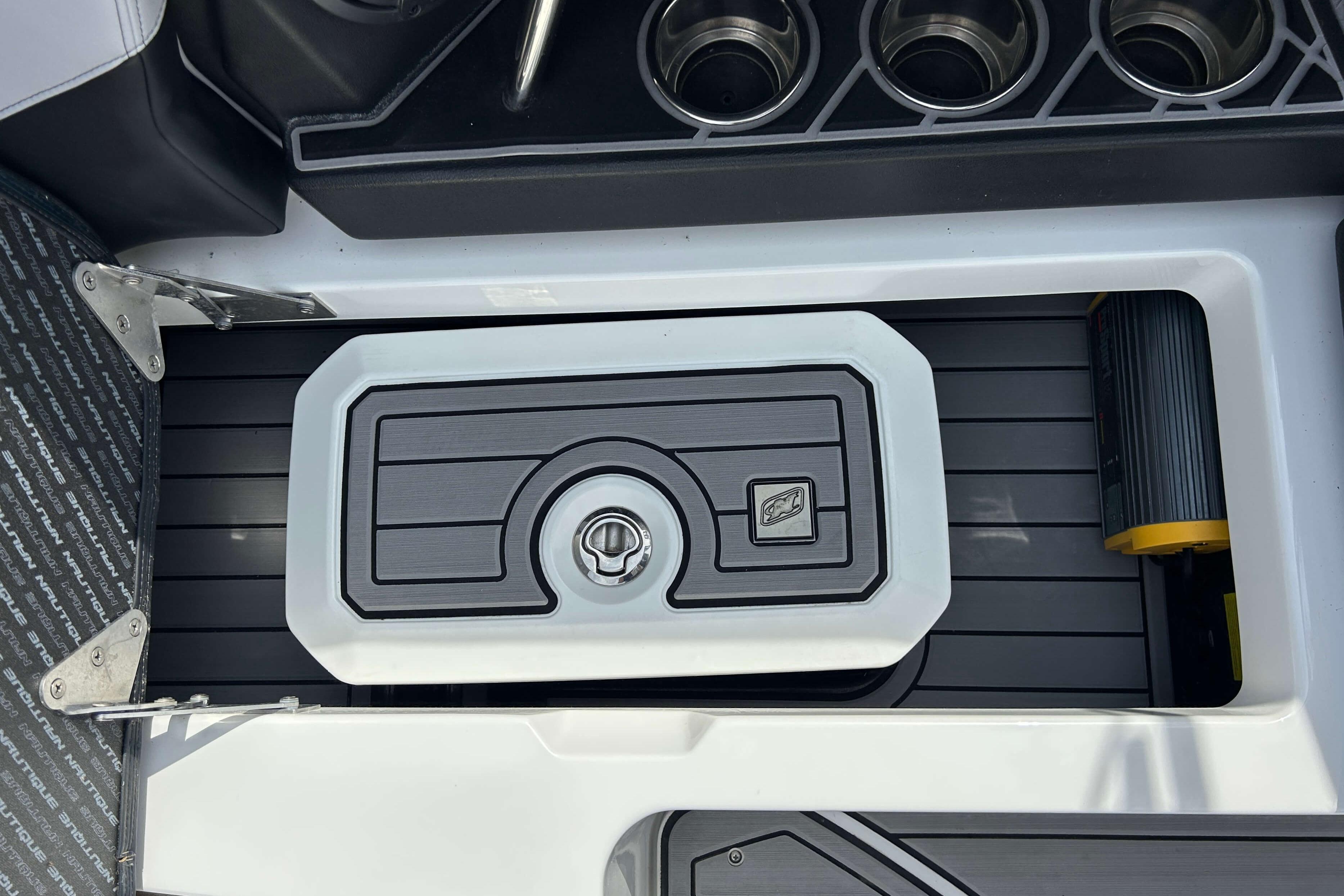 2021 Nautique Super Air Nautique GS24 boat interior with storage compartment and cup holders.