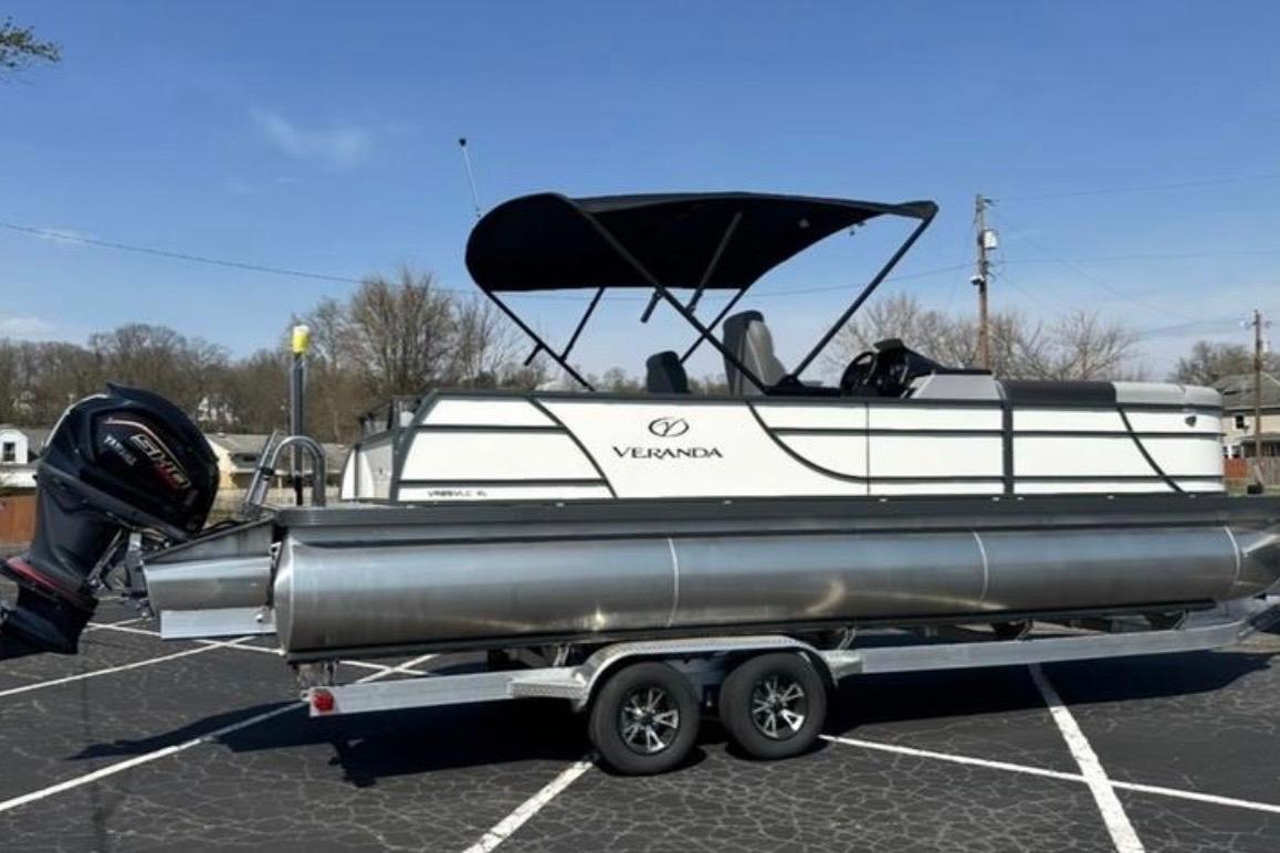 2025 Veranda Relax VR25VLC pontoon boat on trailer, parked outdoors under clear sky.