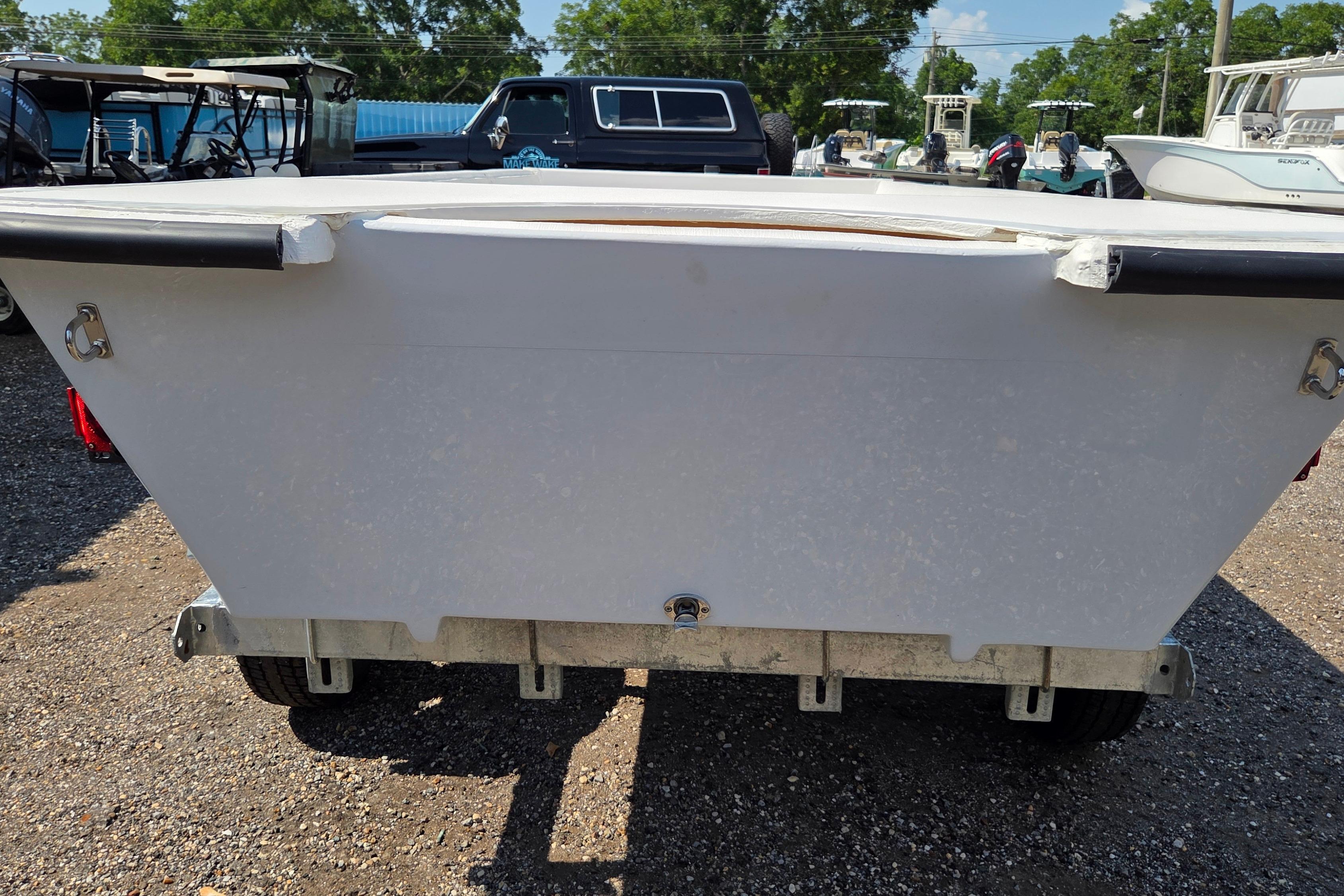 Rear view of a 2027 Delta Boatworks 1550 boat on a trailer in a parking lot.