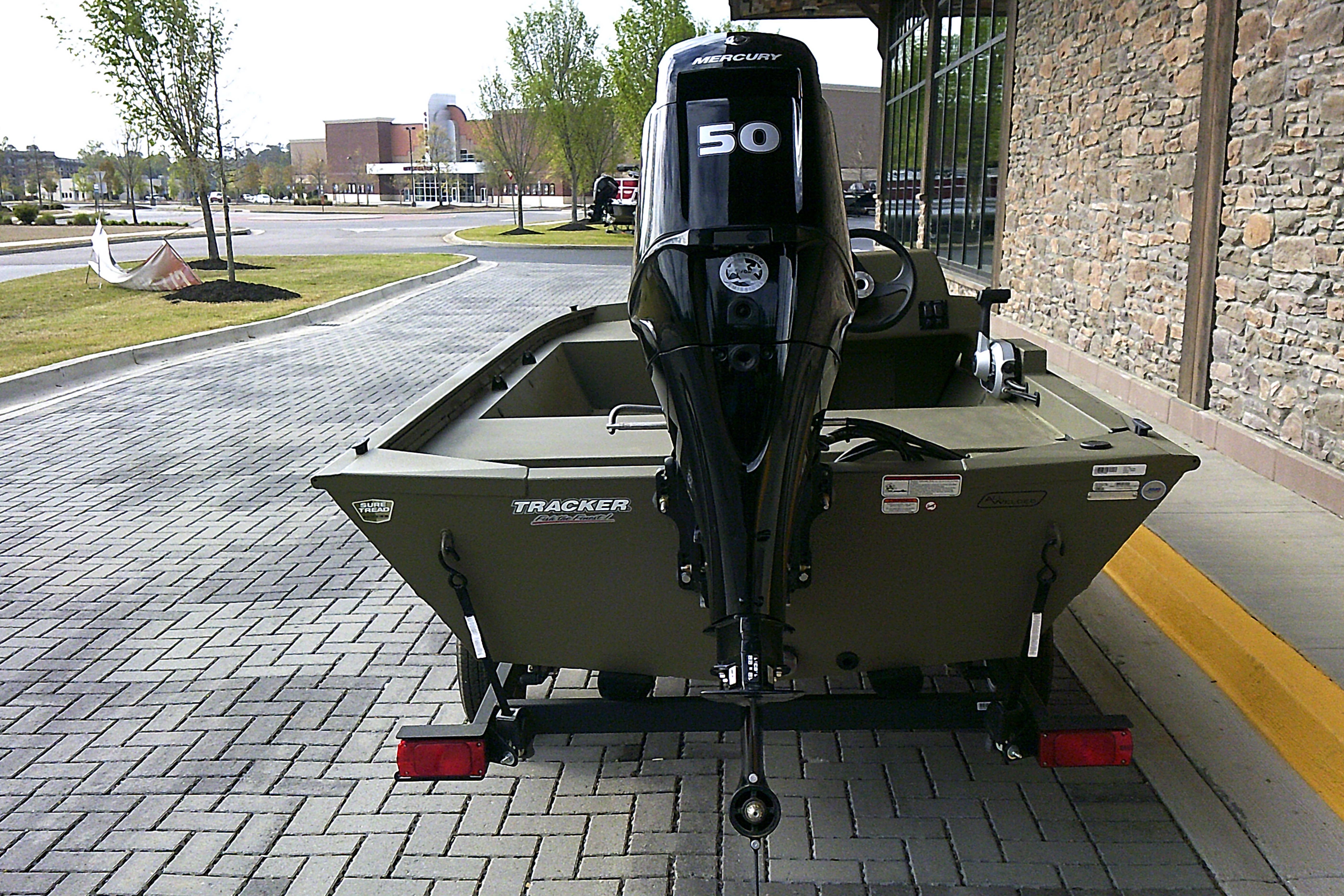 2026 Tracker Grizzly 1648 SC boat with Mercury 50 engine on a paved area.