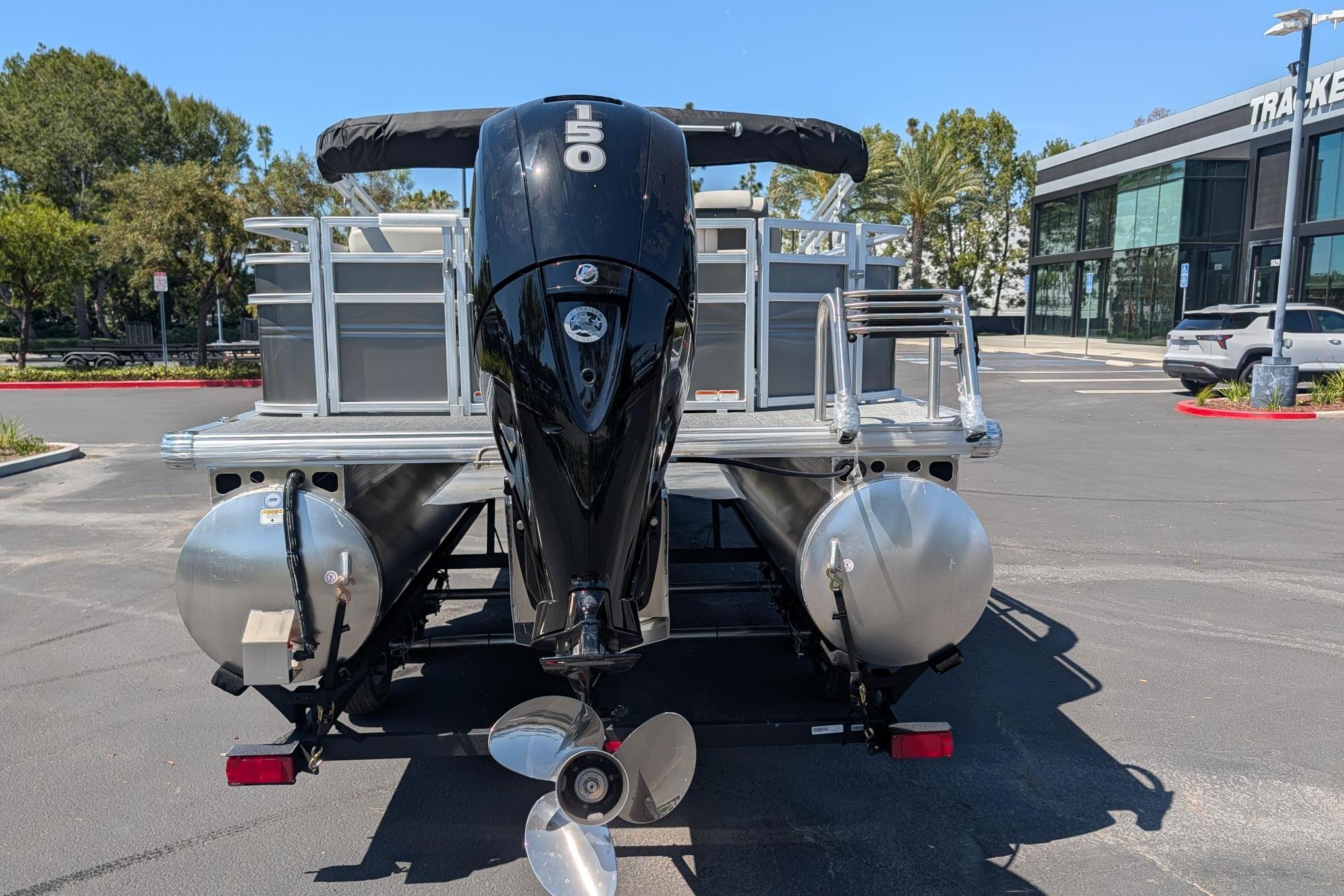 2026 Sun Tracker Fishin' Barge 22 DLX pontoon boat with powerful outboard motor.