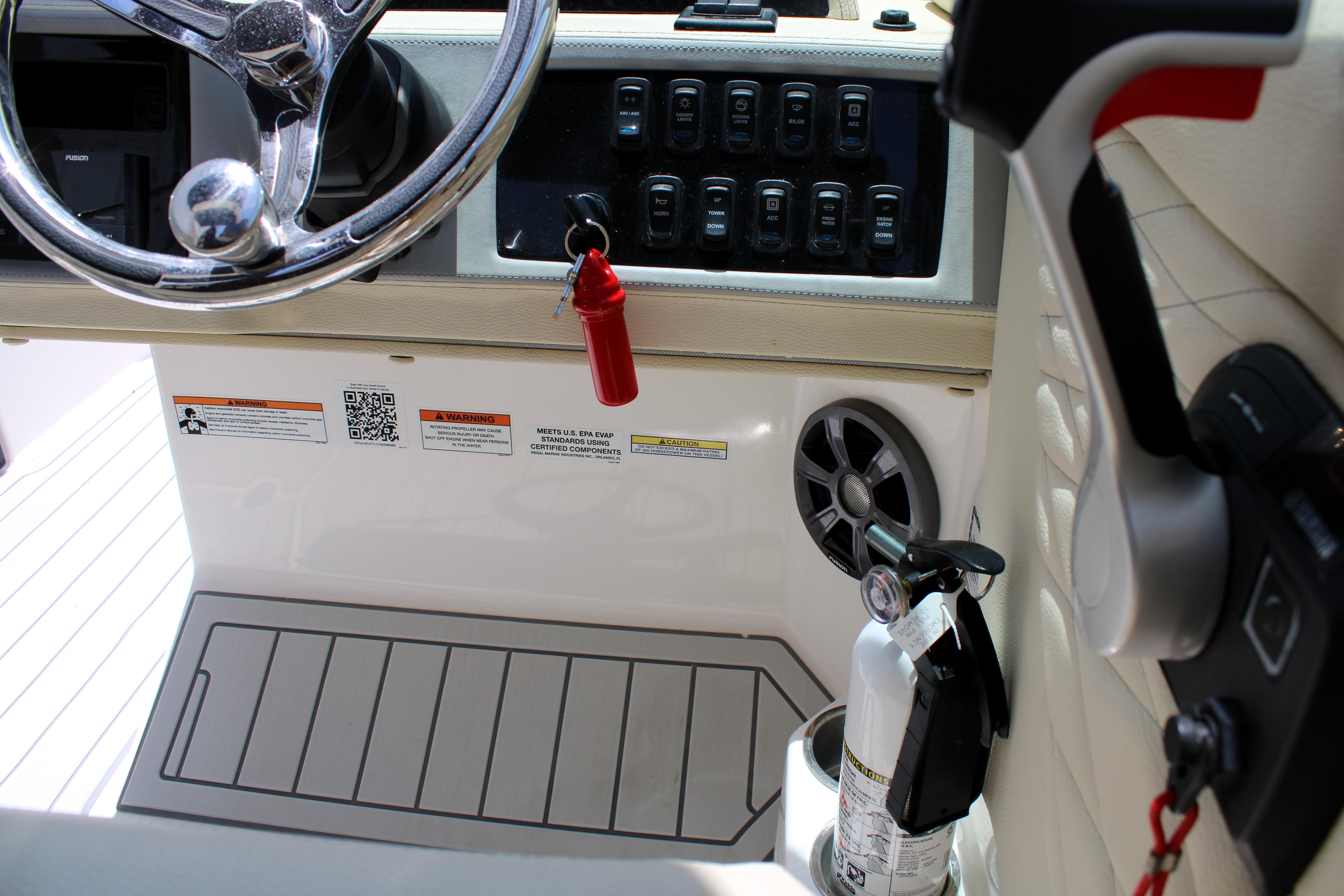 Interior of 2021 Regal 26 OBX boat showing steering wheel, controls, and safety equipment.