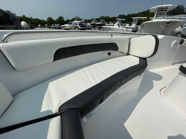 2025 Tidewater 232 CC Adventure boat with white and black seating, docked at a marina.