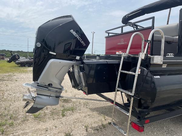 2023 Regency 250DL3 pontoon boat with Mercury outboard motor and ladder, parked on gravel.