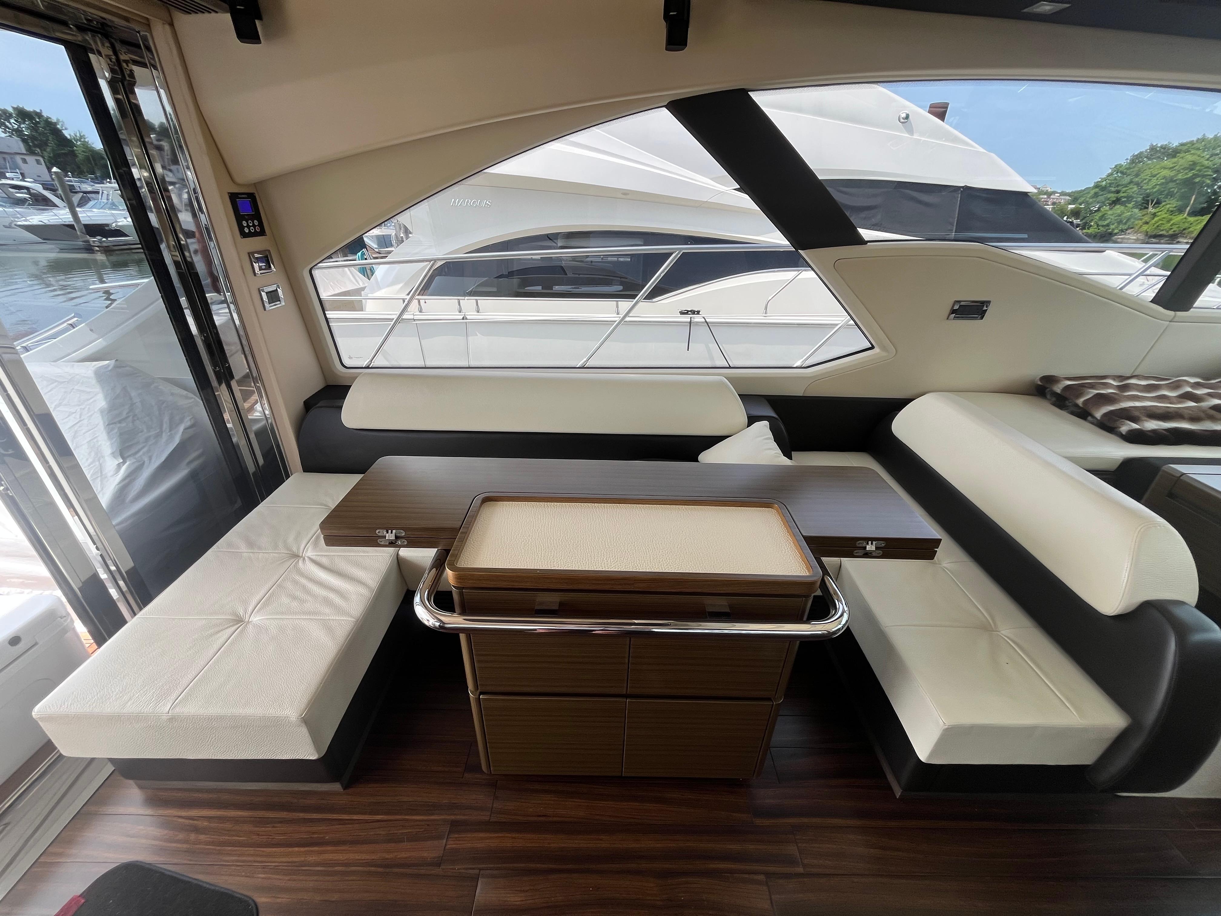Interior of 2014 Azimut 55S yacht with elegant seating and wooden flooring.