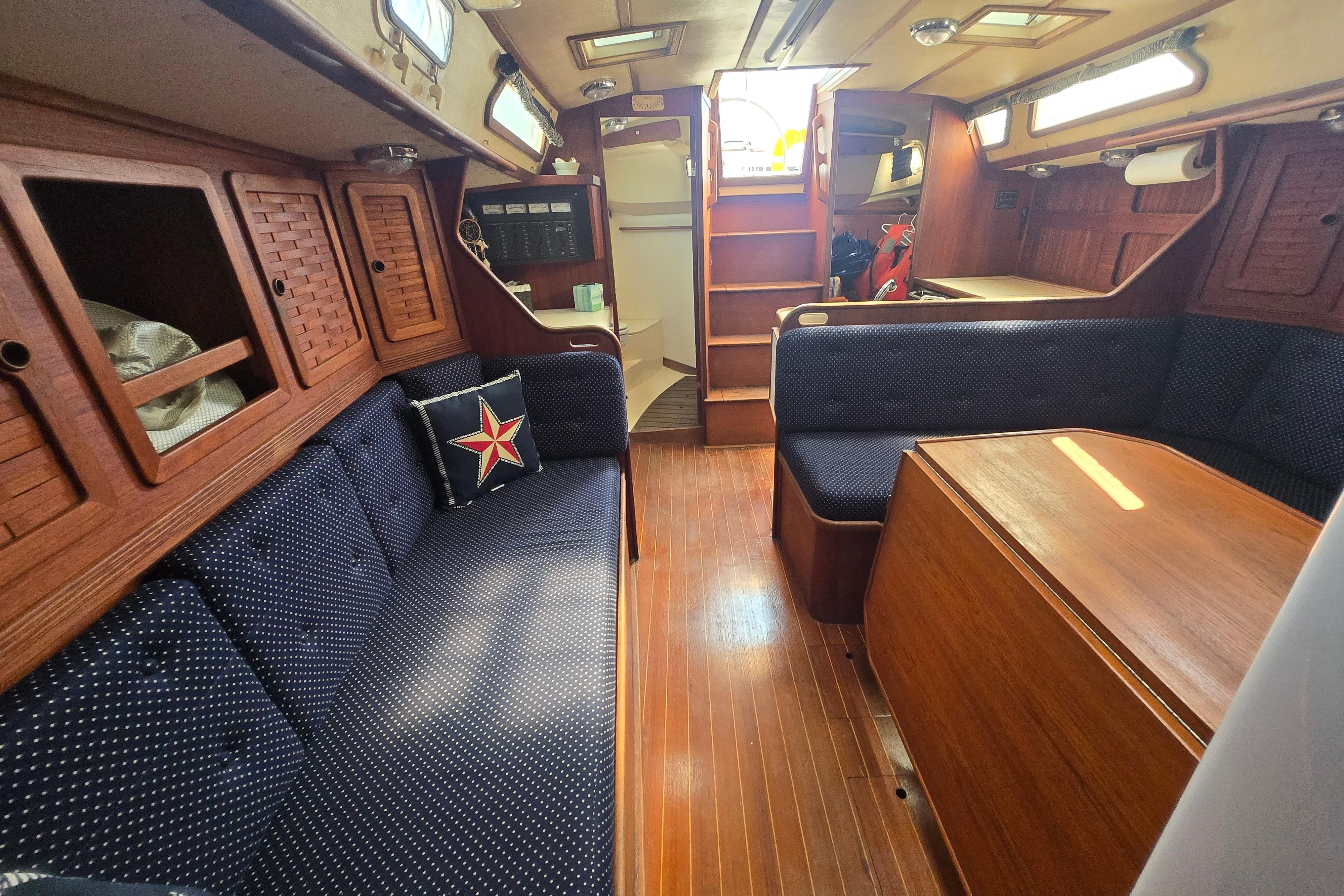 Interior of 1988 Sabre 38 sailboat with wooden finish and blue upholstery.