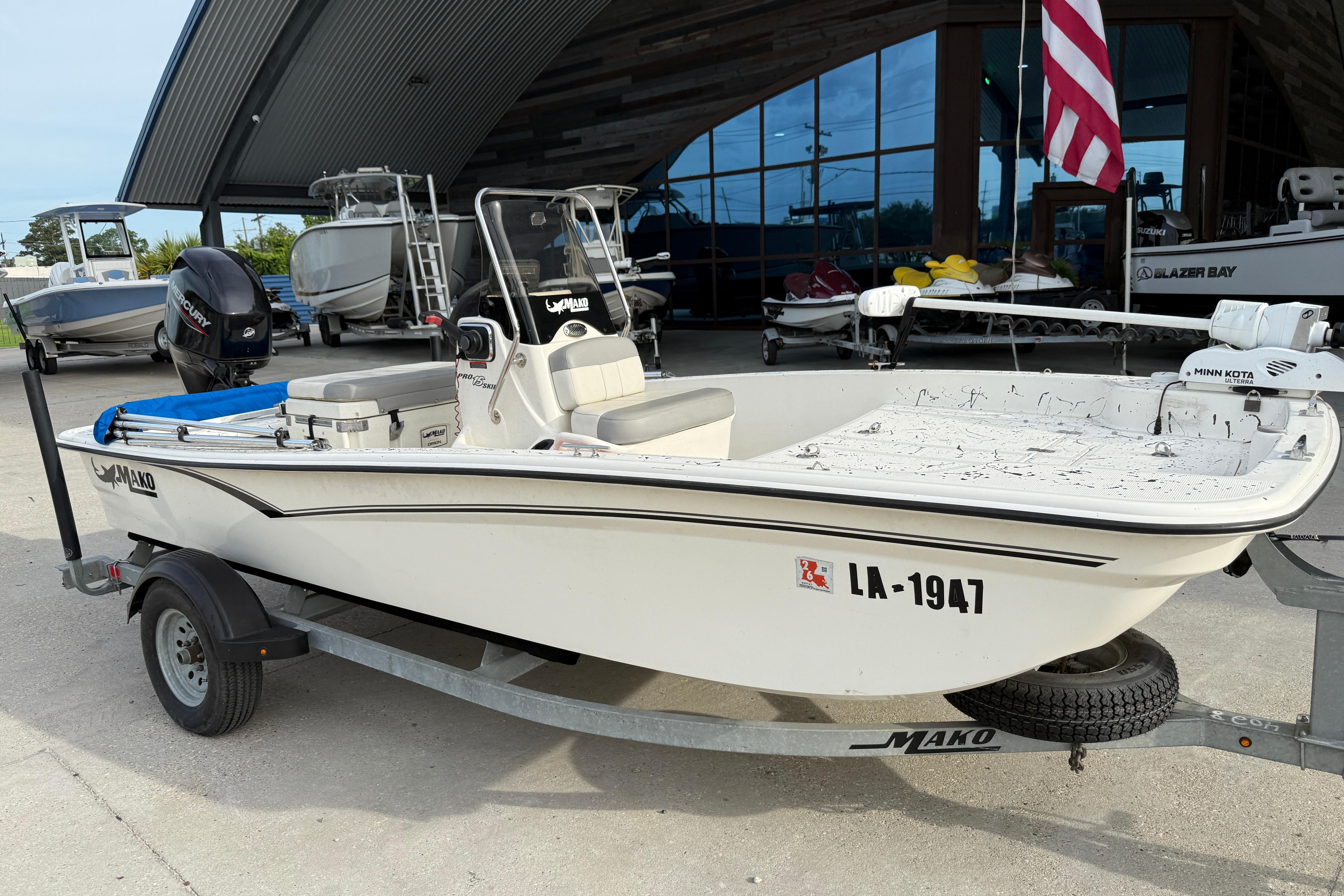 2020 Mako Pro Skiff 15 CC boat on trailer, parked outdoors near other boats.