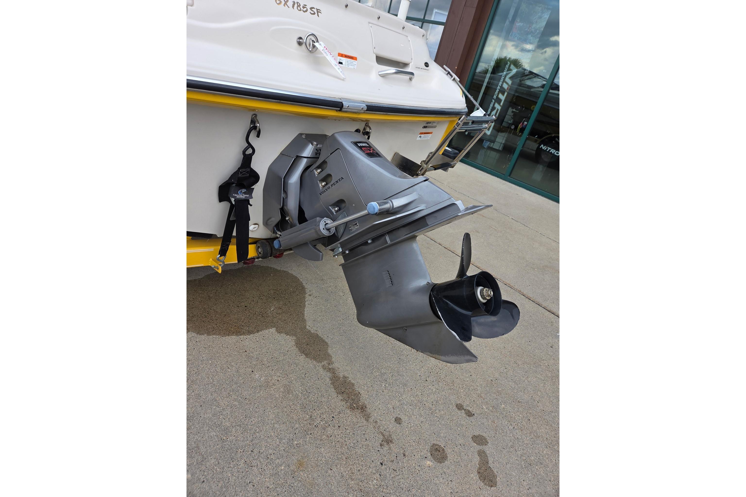 2003 Glastron GX185SF boat with outboard motor on concrete surface.