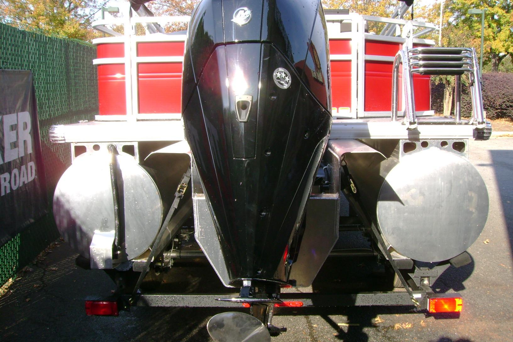 2026 Sun Tracker Fishin' Barge 22 XP3 pontoon boat rear view with powerful outboard motor.