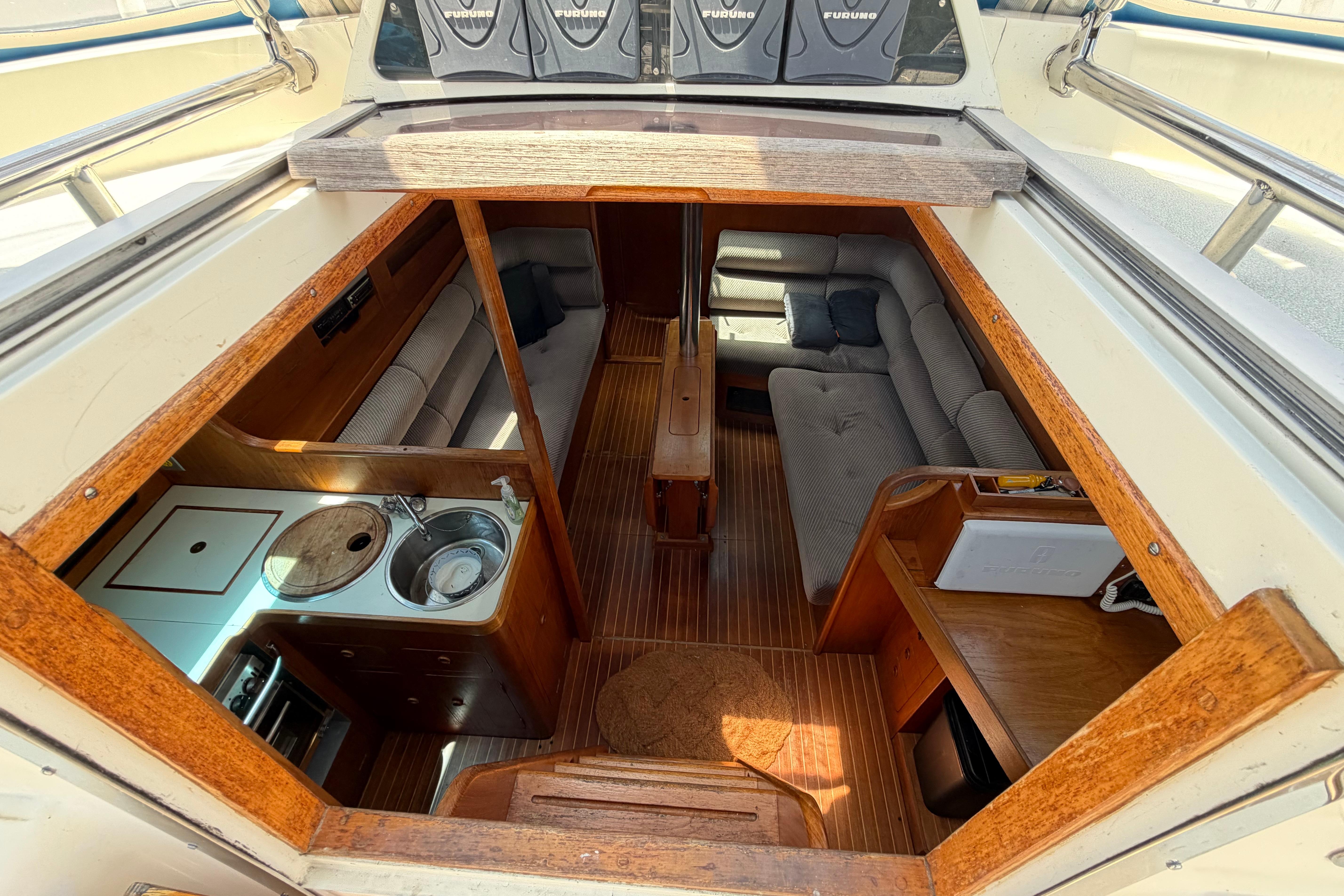 Interior of a 1987 Moody 376 yacht featuring a cozy cabin and kitchenette.