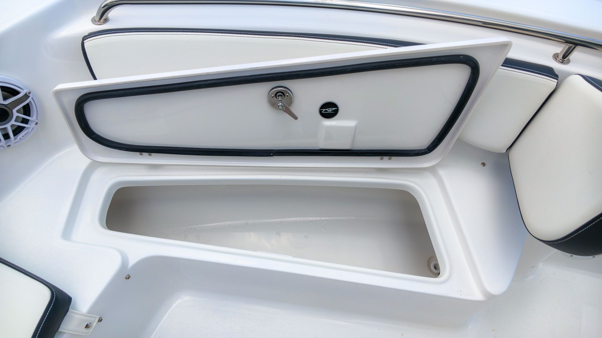 Boat storage compartment with open hatch and speaker.