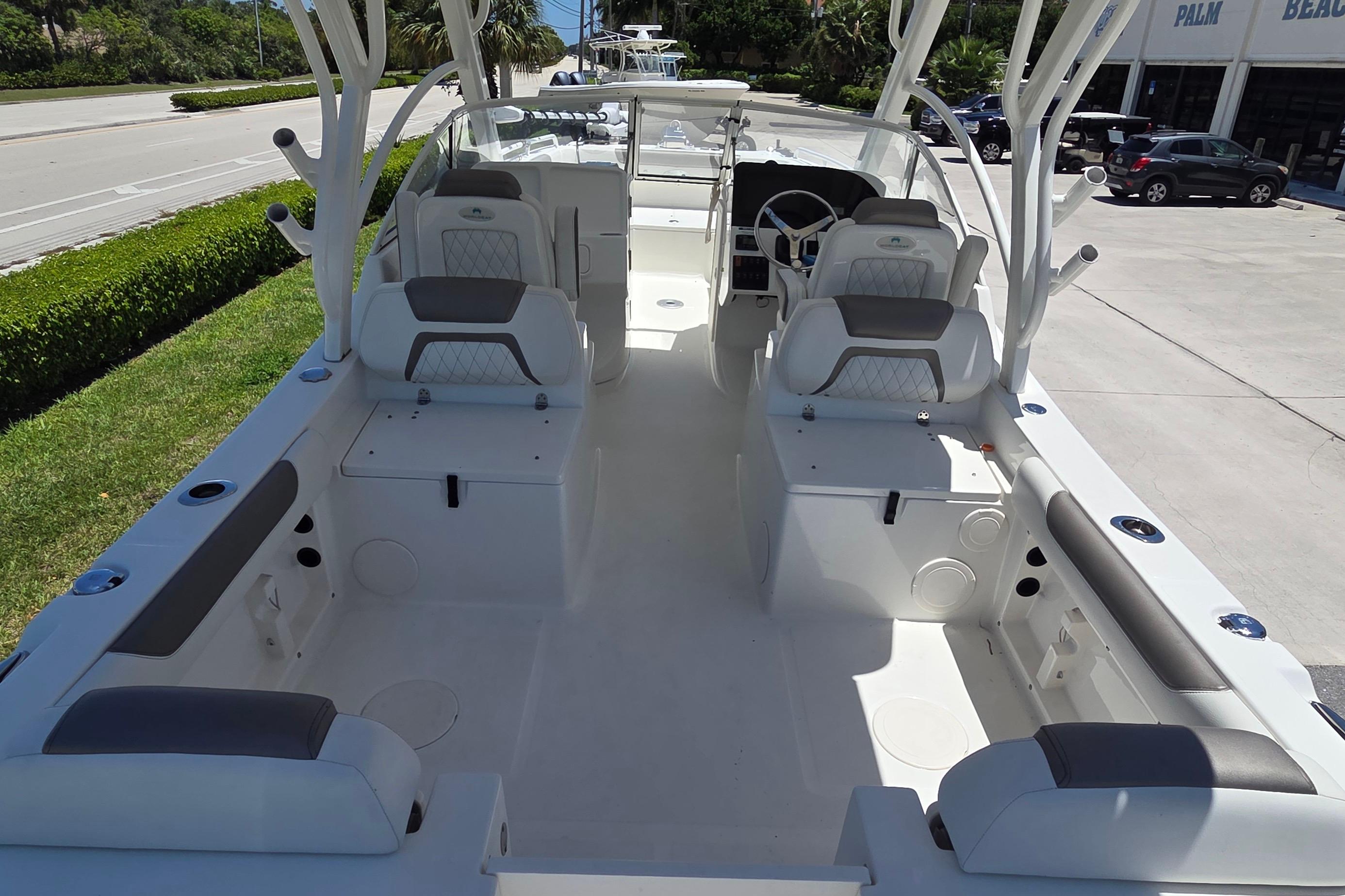 2022 World Cat 255 DC boat interior with seating and steering wheel, parked outdoors.