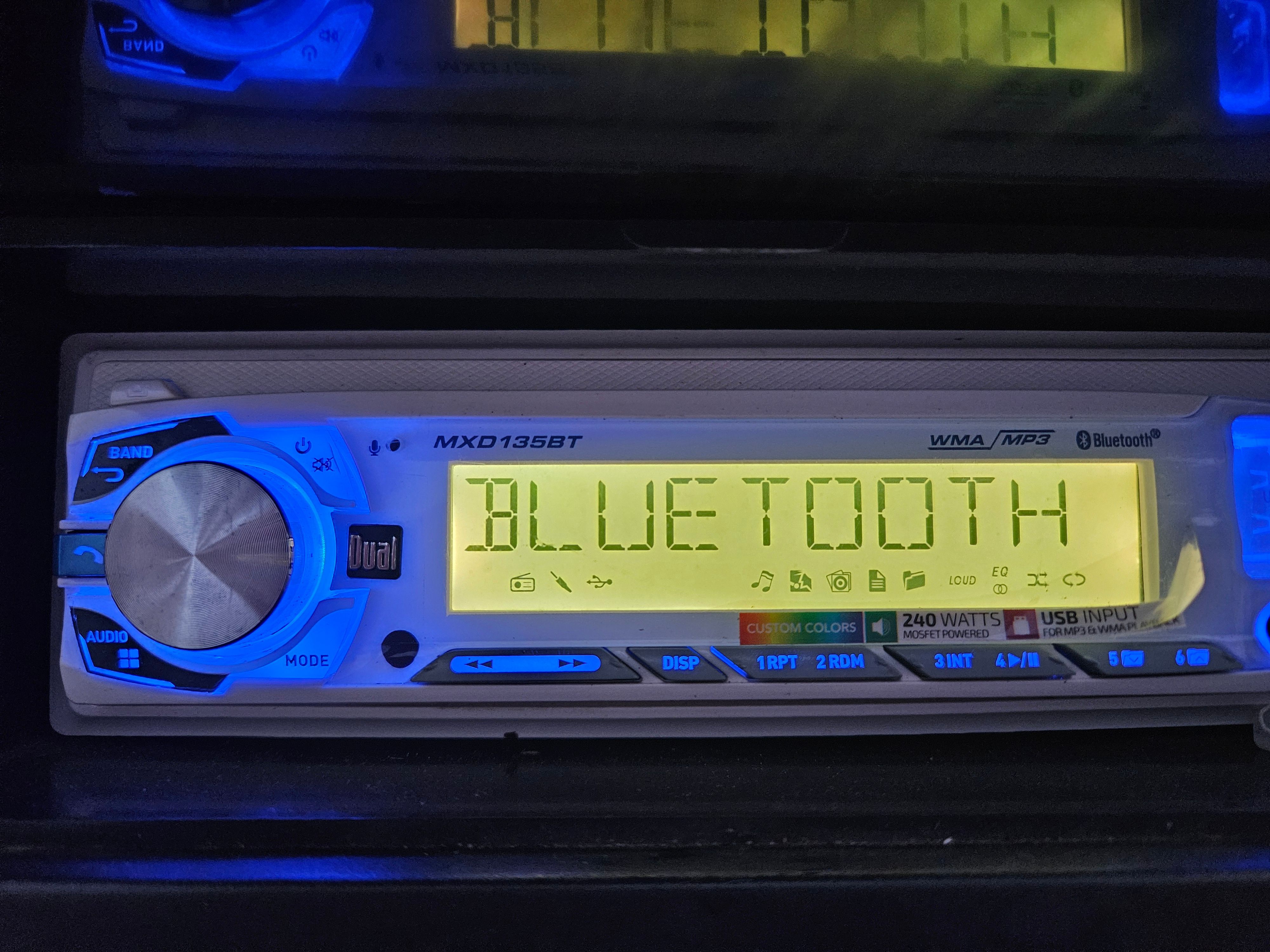 A Dual car stereo with Bluetooth display and blue backlighting.