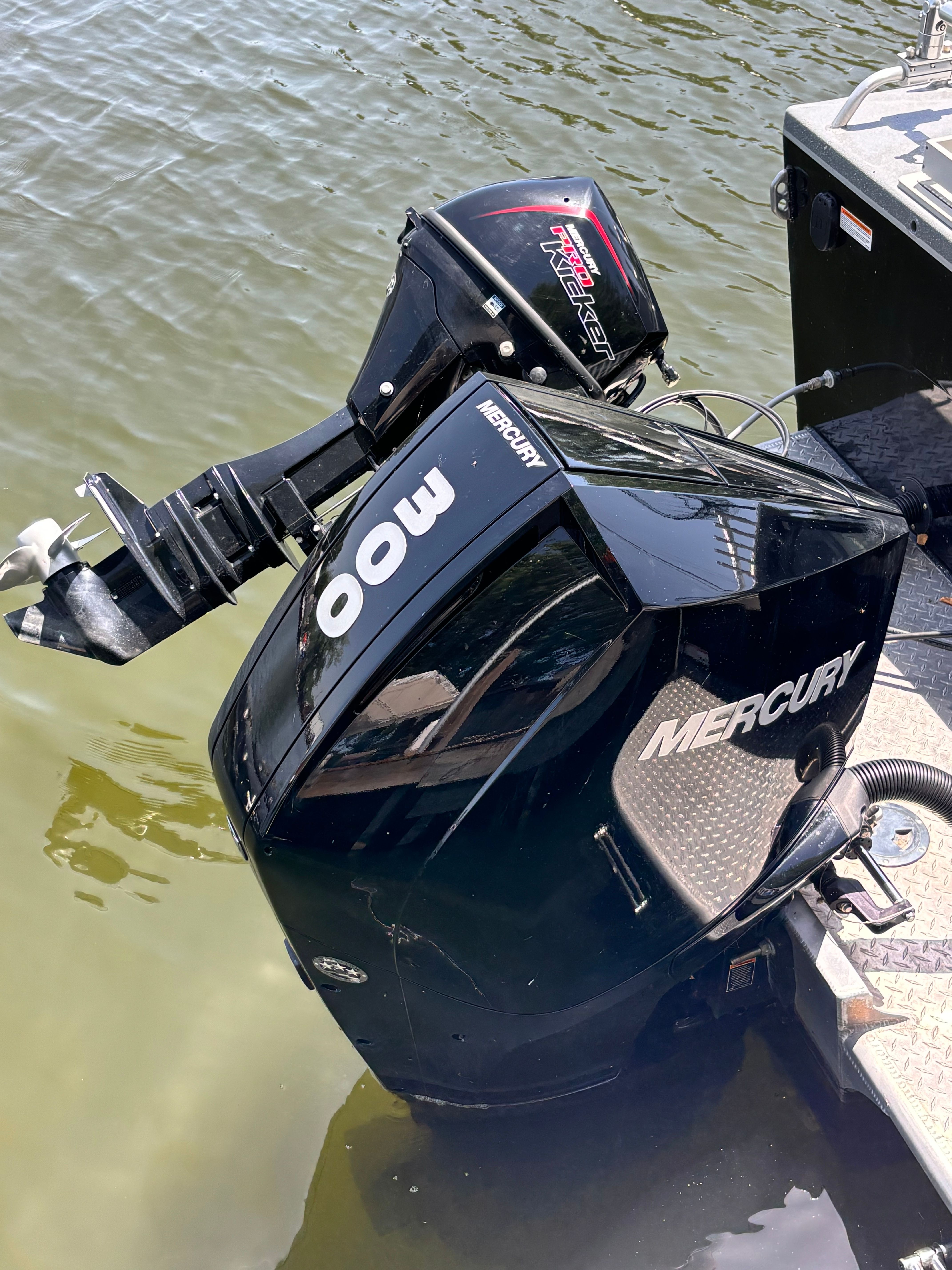 A Mercury outboard motor is attached to a boat floating on the water.