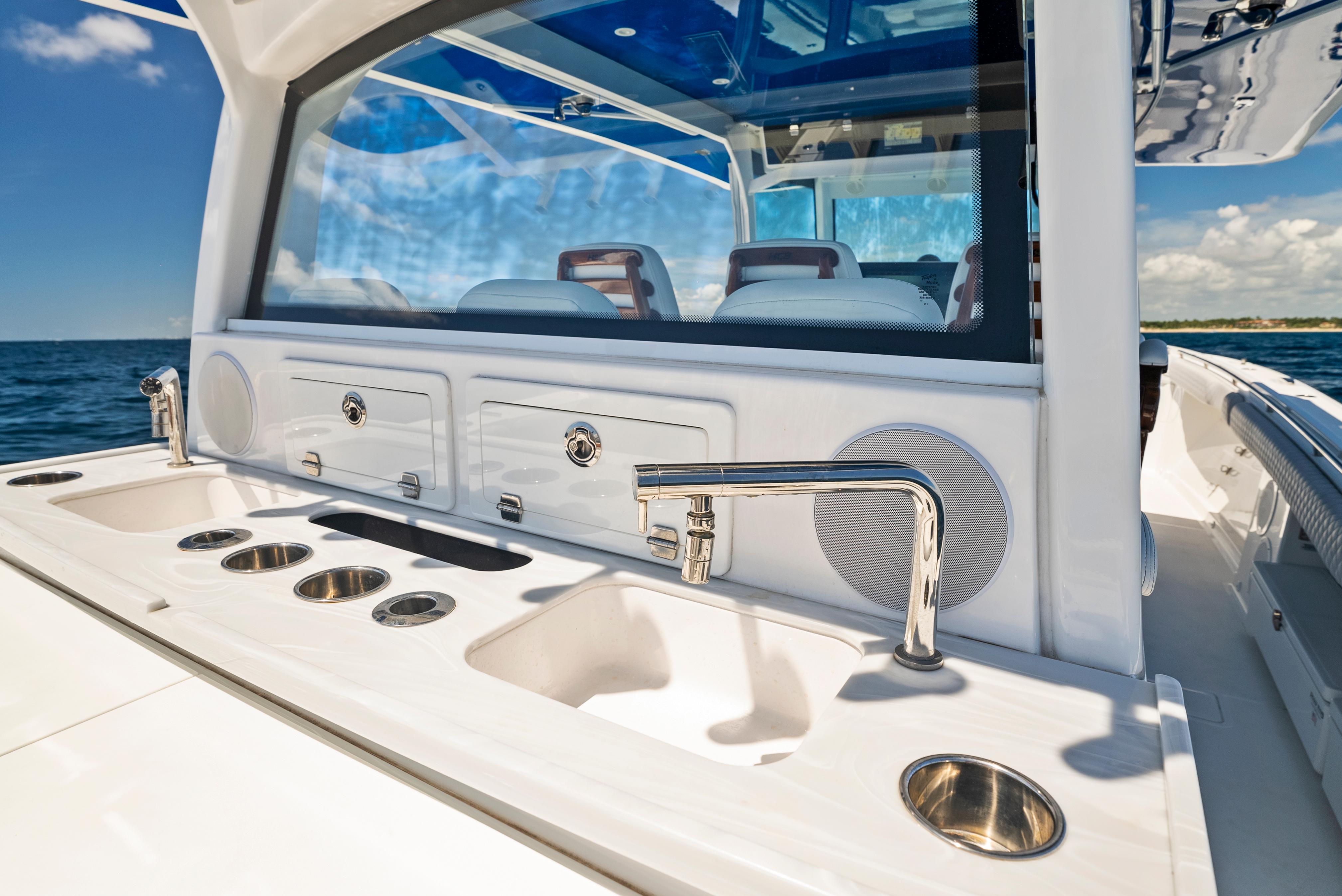 2022 HCB Suenos boat interior with sleek sink and faucet, ocean view in background.
