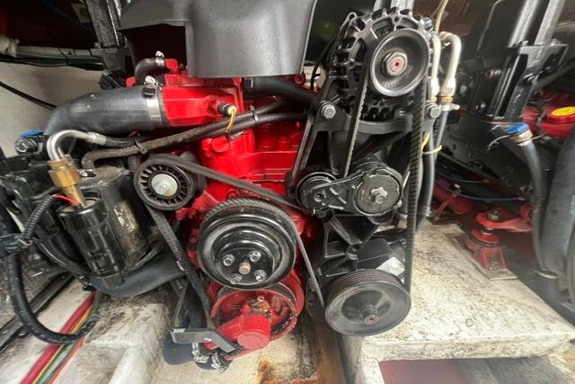 Engine compartment of a 2004 Cruisers Yachts 3372 Express, showcasing mechanical components and belts.