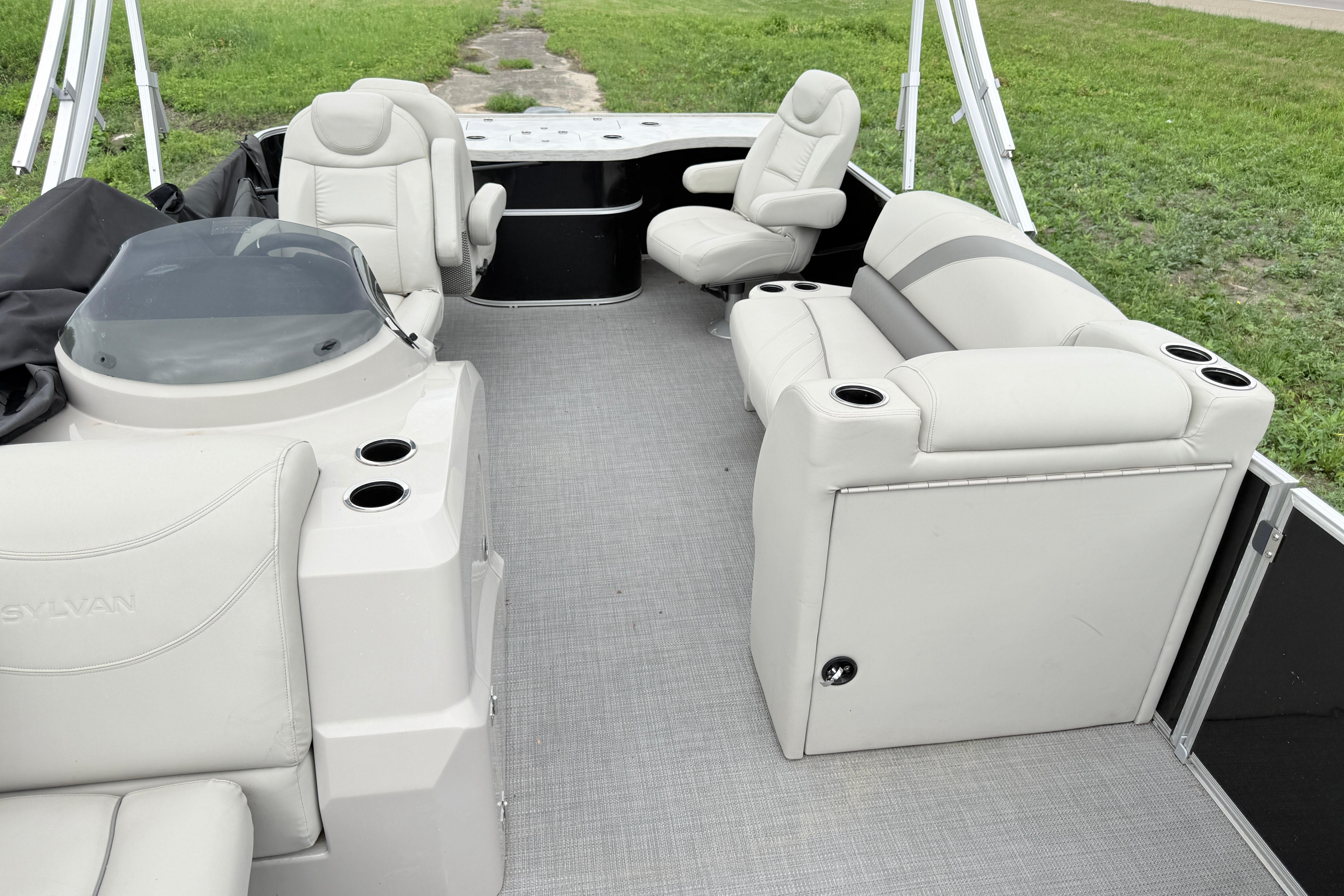 2019 Sylvan 8522 Mirage Signature F-n-C pontoon boat interior with plush seating and cup holders.