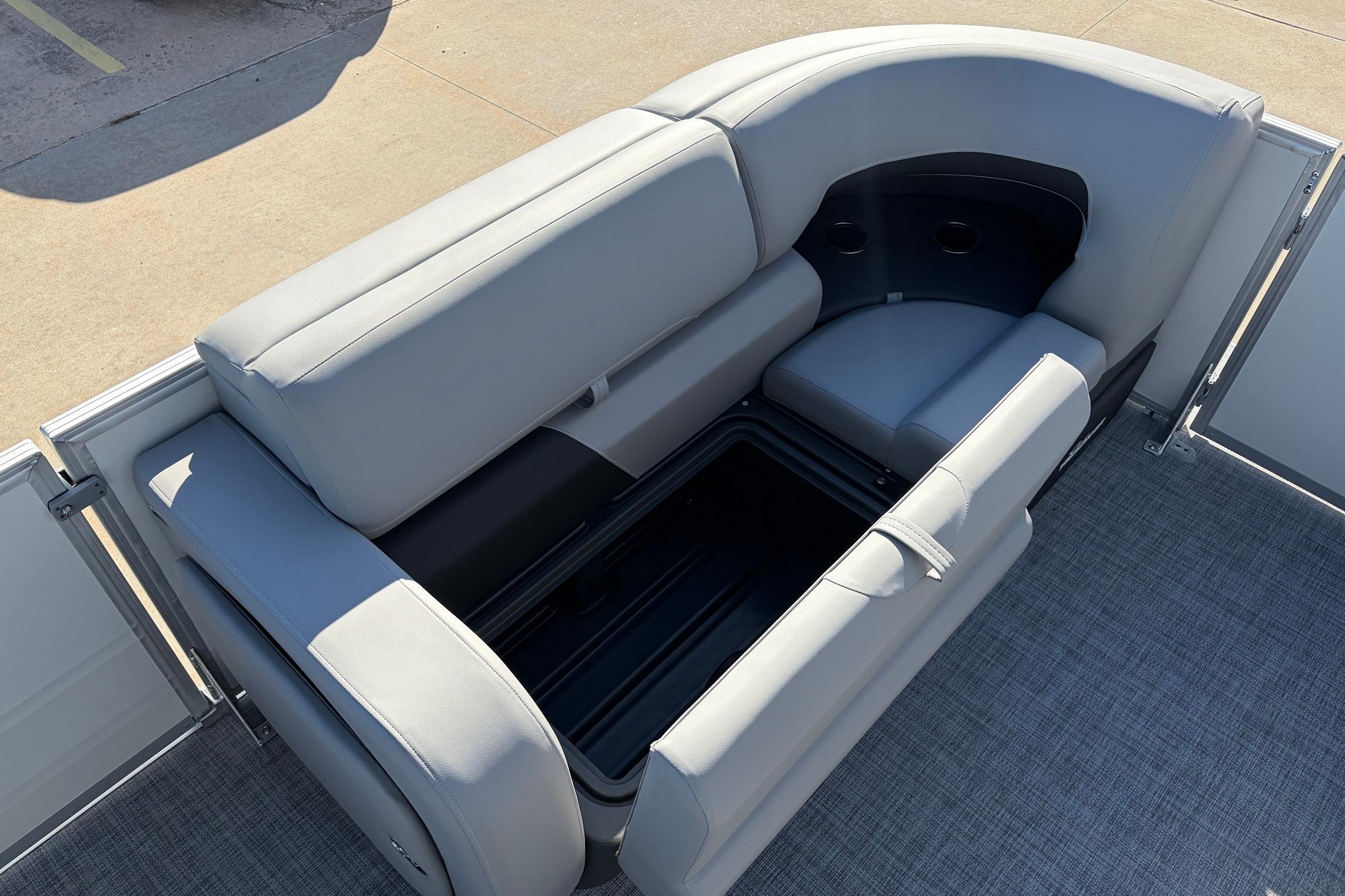 Sun Tracker Party Barge 22 RF XP3 2026 with open storage compartment on gray seating.