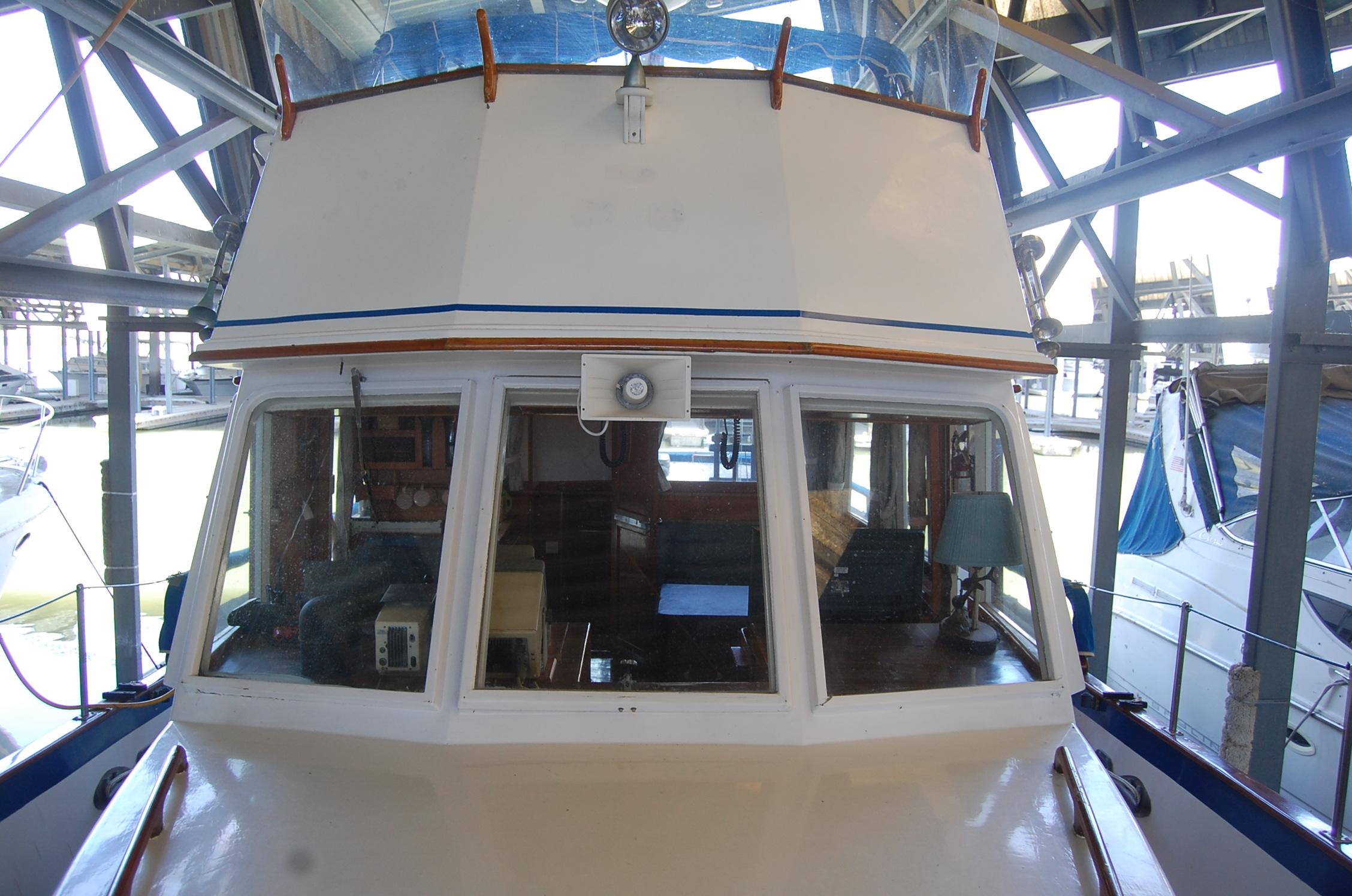 1983 Island Gypsy 36 Quad Cabin boat docked in a marina, front view.