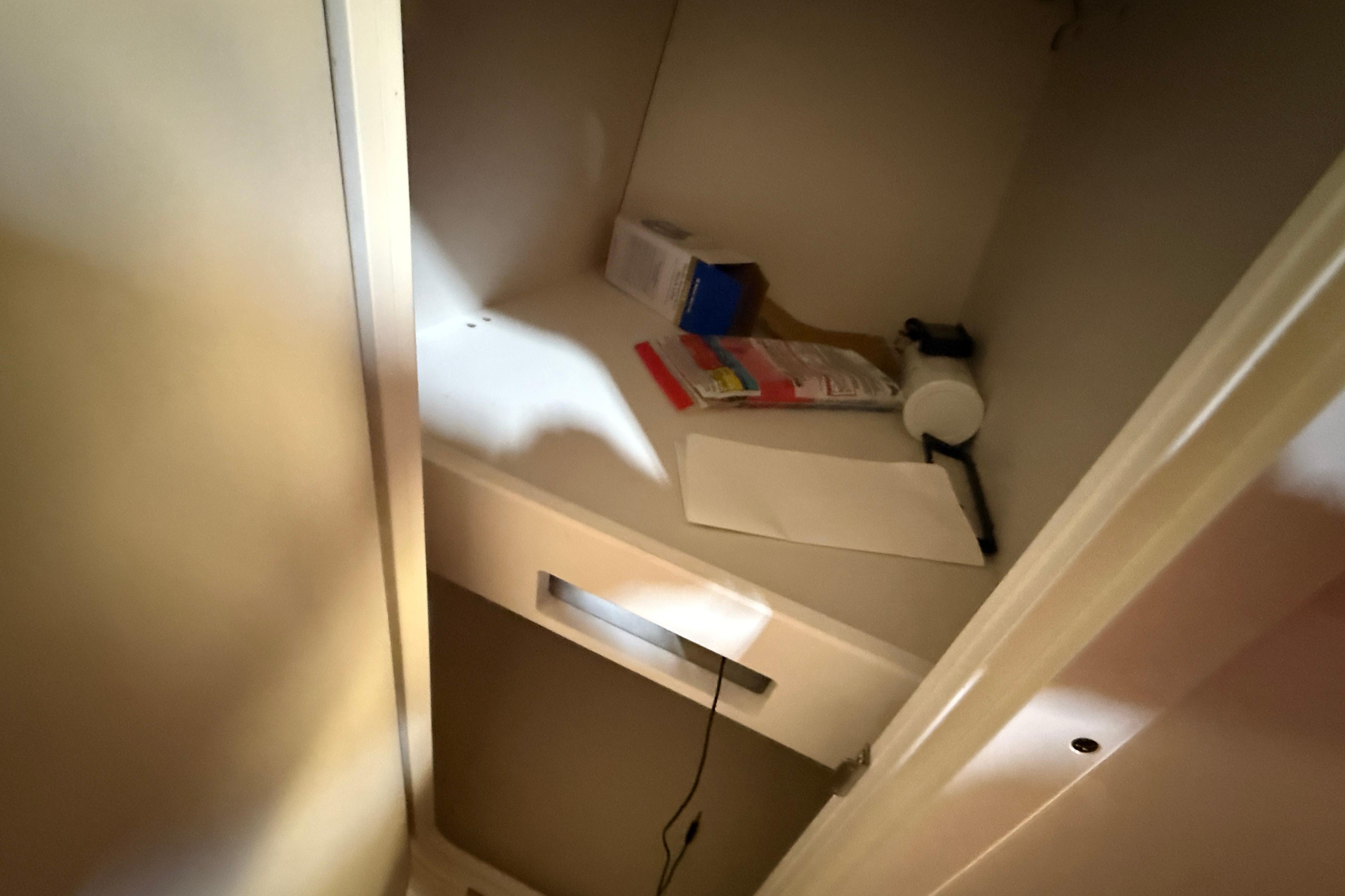 Interior storage compartment of 2013 Rinker 276 Captiva Bowrider with miscellaneous items.