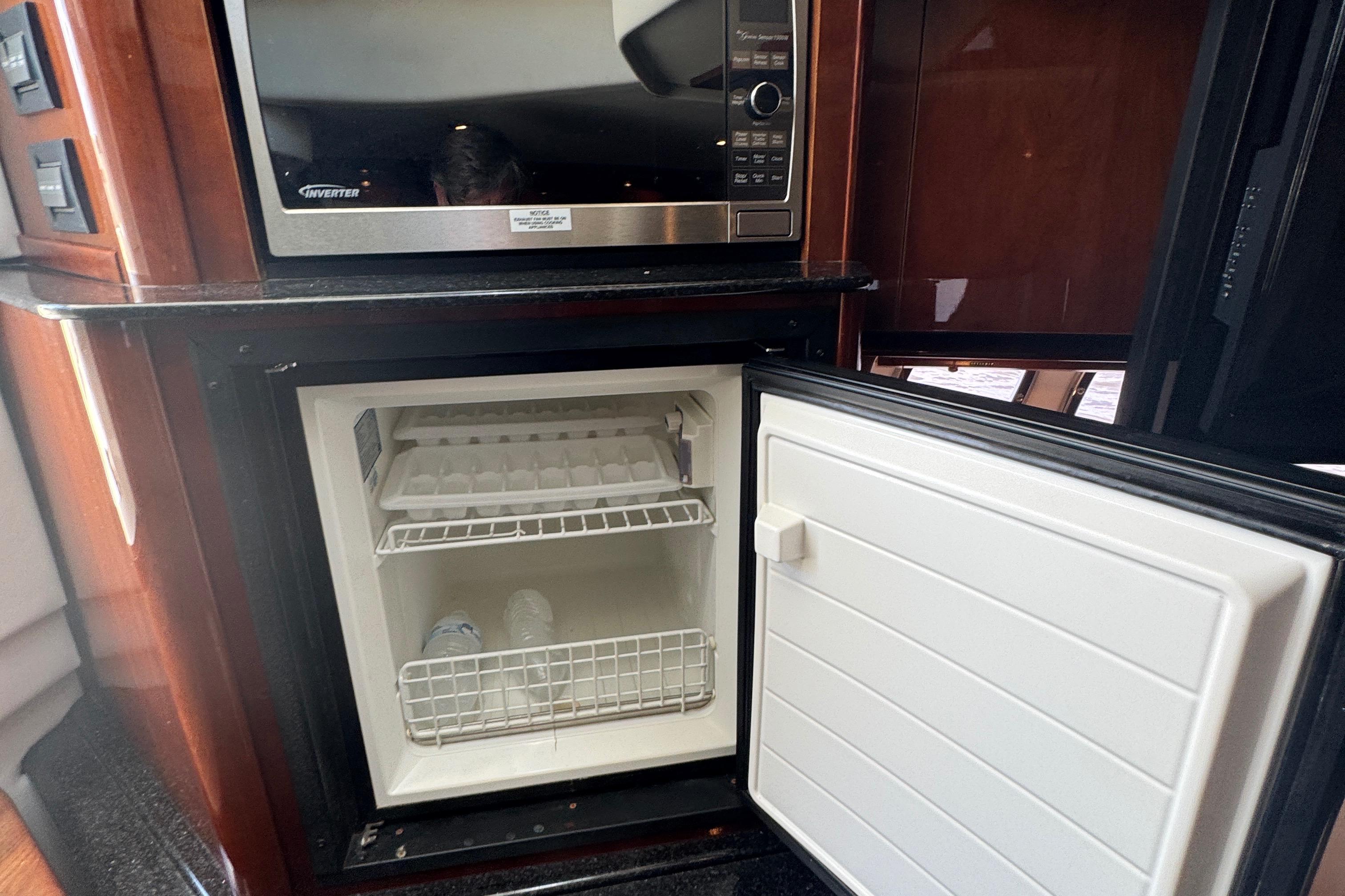 Open mini fridge and microwave in 2010 Sea Ray 390 Sundancer yacht kitchen.