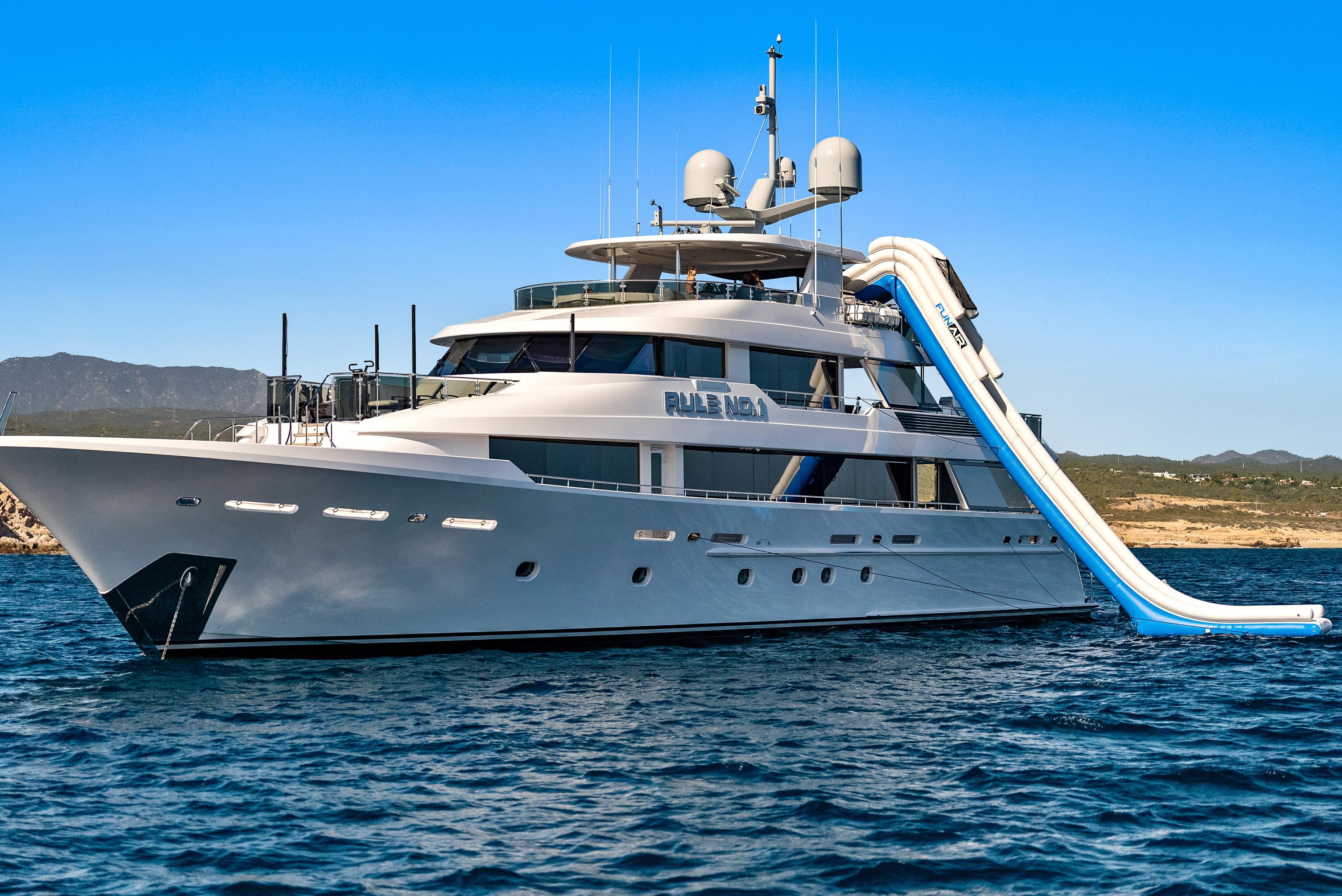 Luxurious 2011 Westport 40-meter yacht with waterslide, anchored in scenic waters.