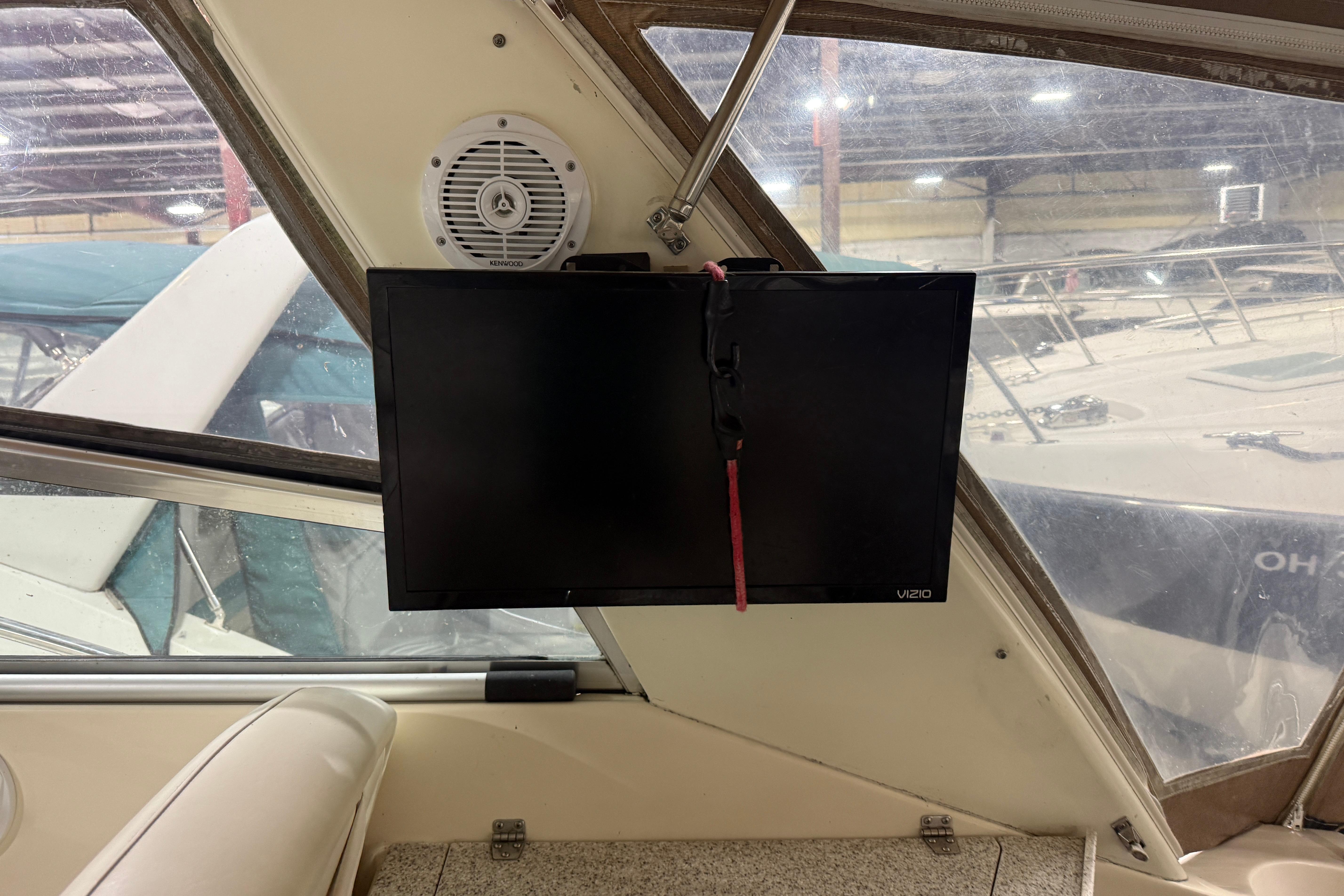 Interior of 2002 Rinker Fiesta Vee 342 with mounted Vizio TV and Kenwood speaker.
