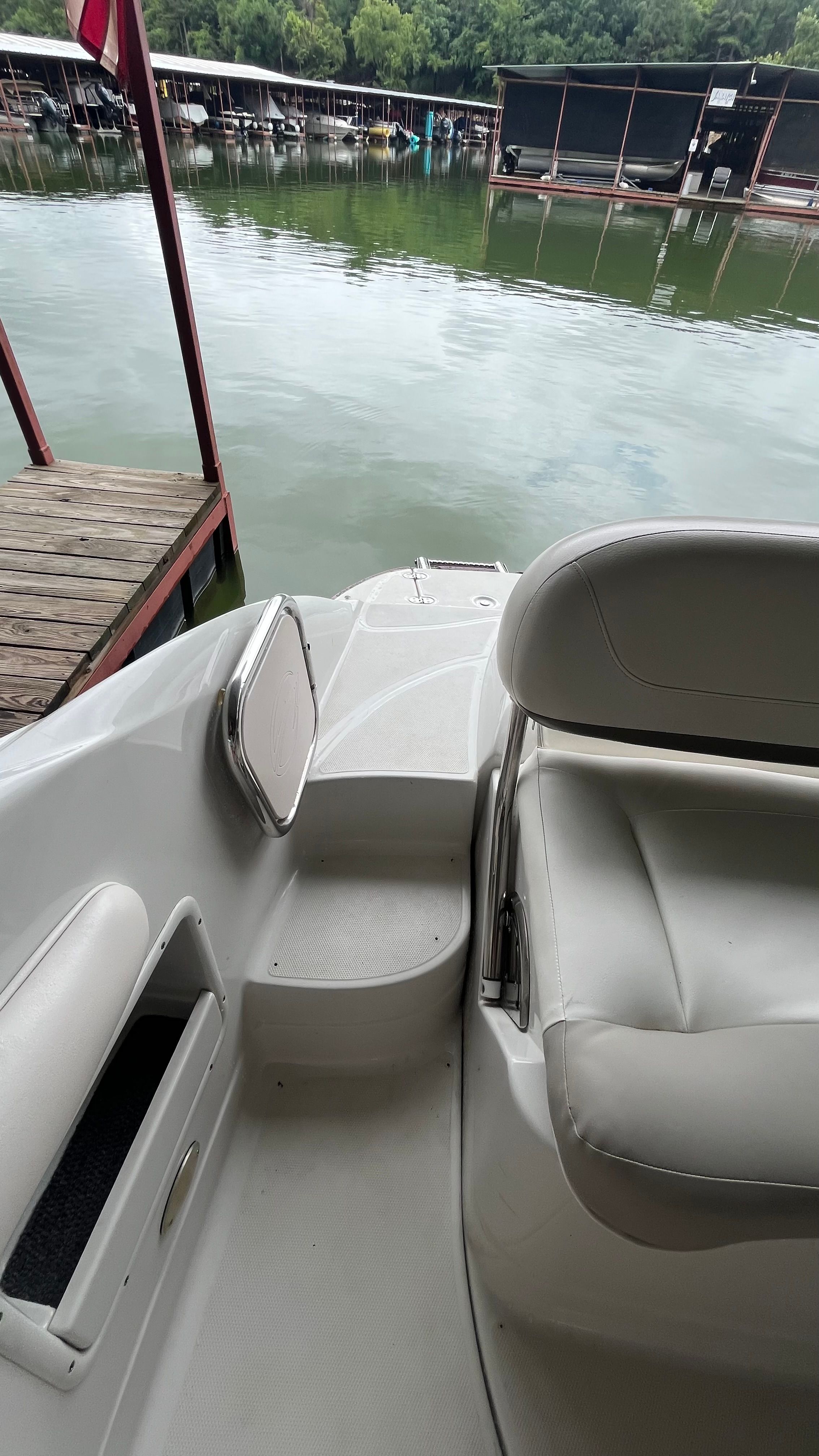 The image shows the stern of a 2008 Crownline 252EX boat docked at a pier.