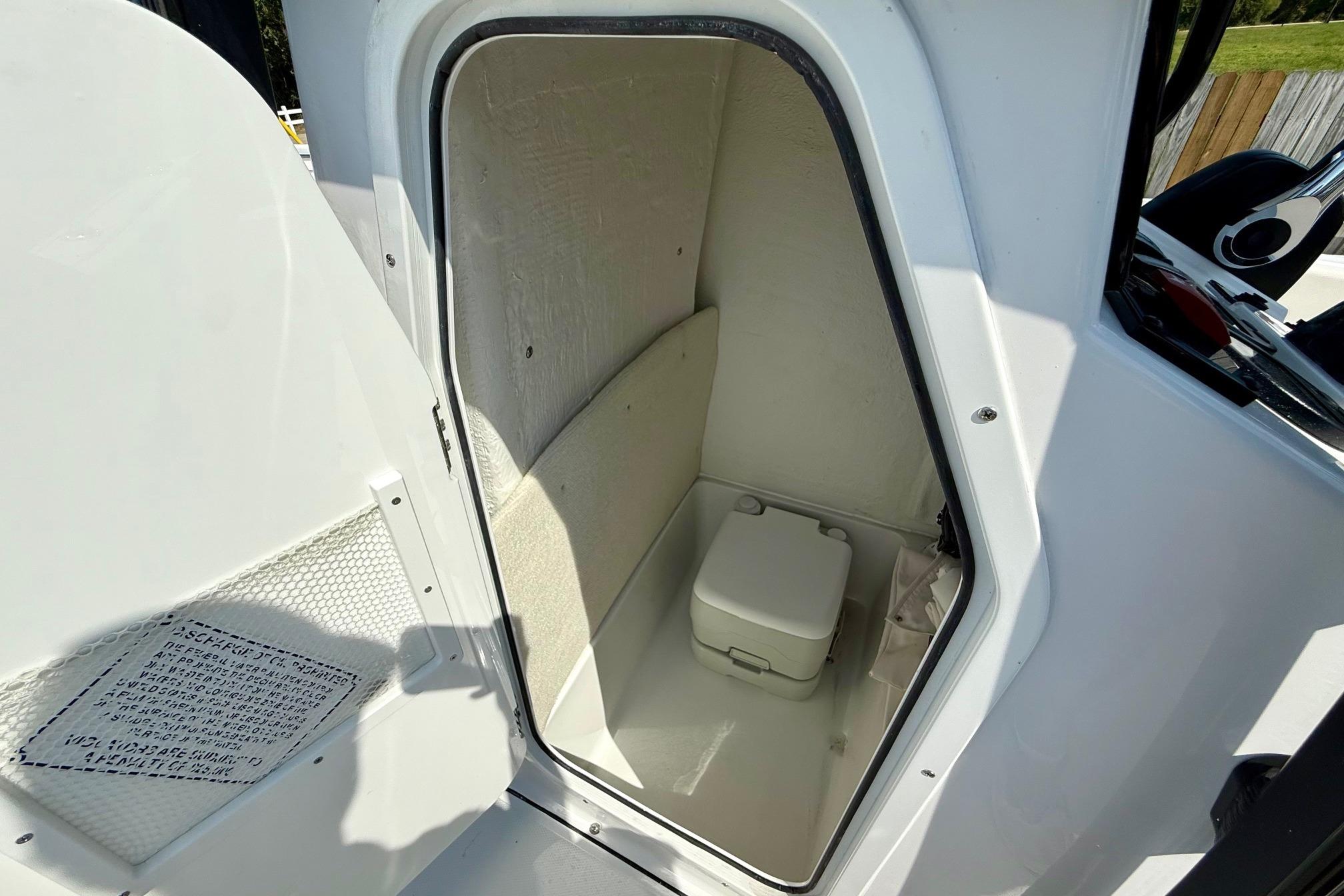 Compact marine toilet compartment in 2026 Sea Hunt Ultra 229 boat.