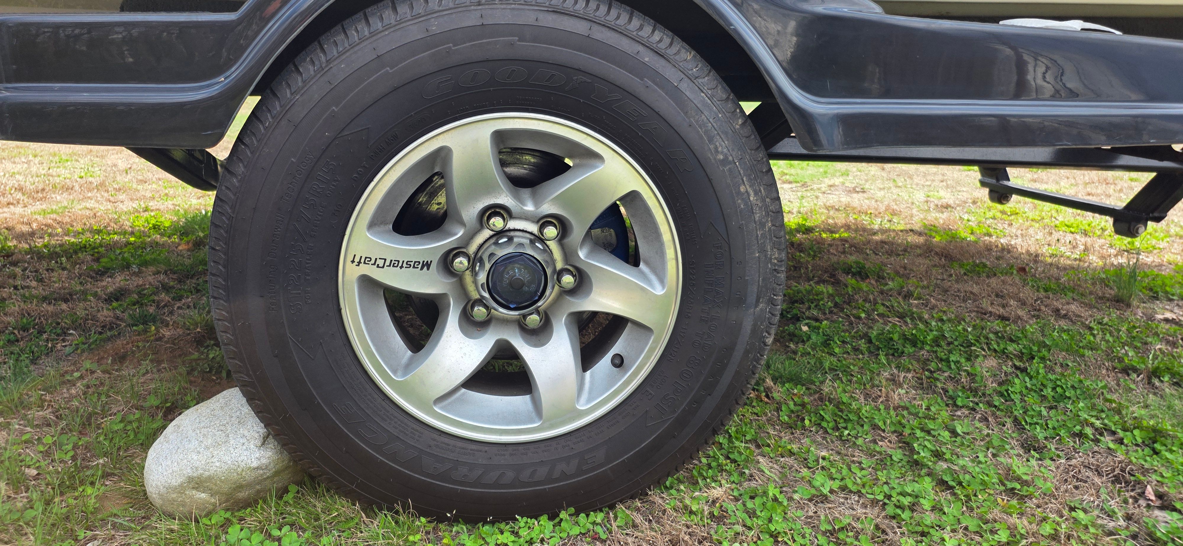 Tire of a 2004 MasterCraft Maristar boat trailer on grass.