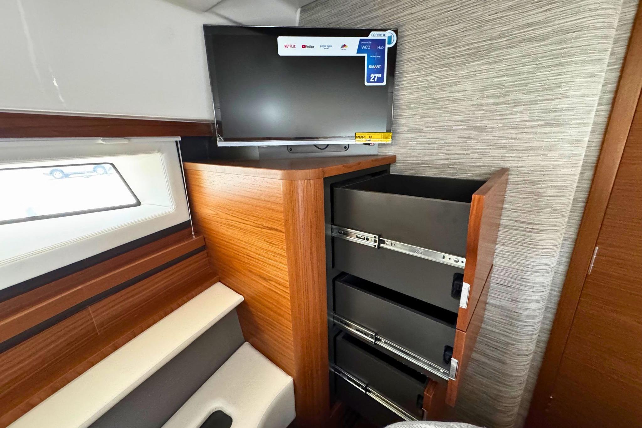 2027 Tiara Yachts 39 LE interior with TV and open storage drawers.