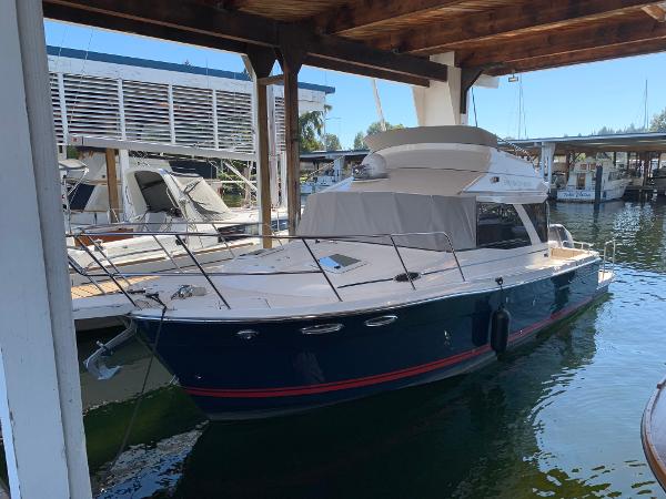 2021 Cutwater C-32 CB boat docked in a marina under a wooden shelter.