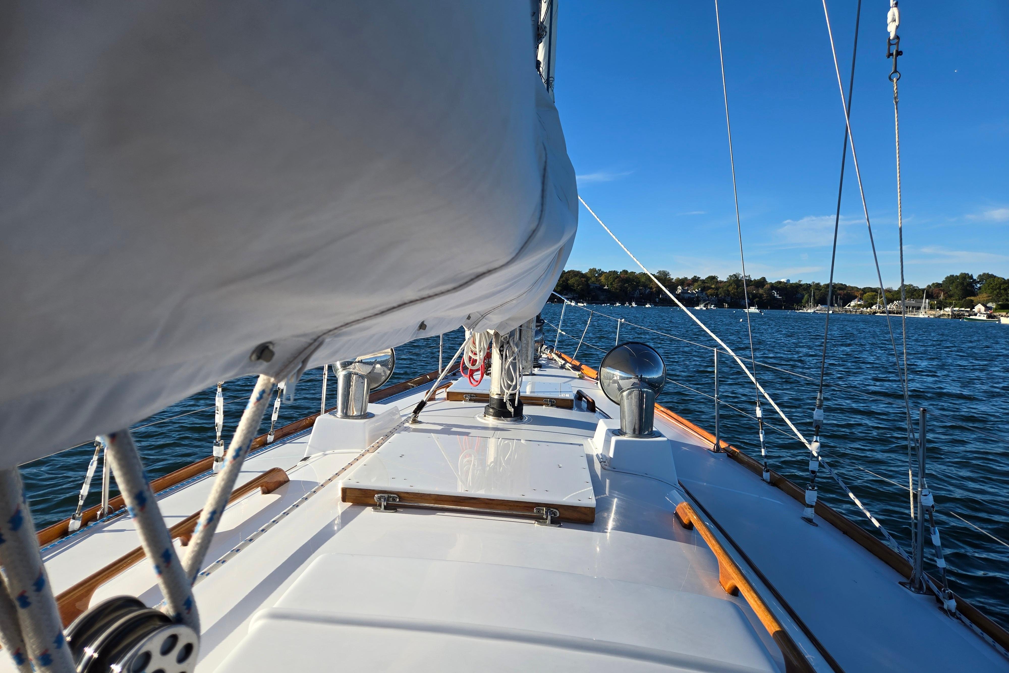 1970 Hinckley Bermuda 40 sailboat on calm waters under clear blue sky.