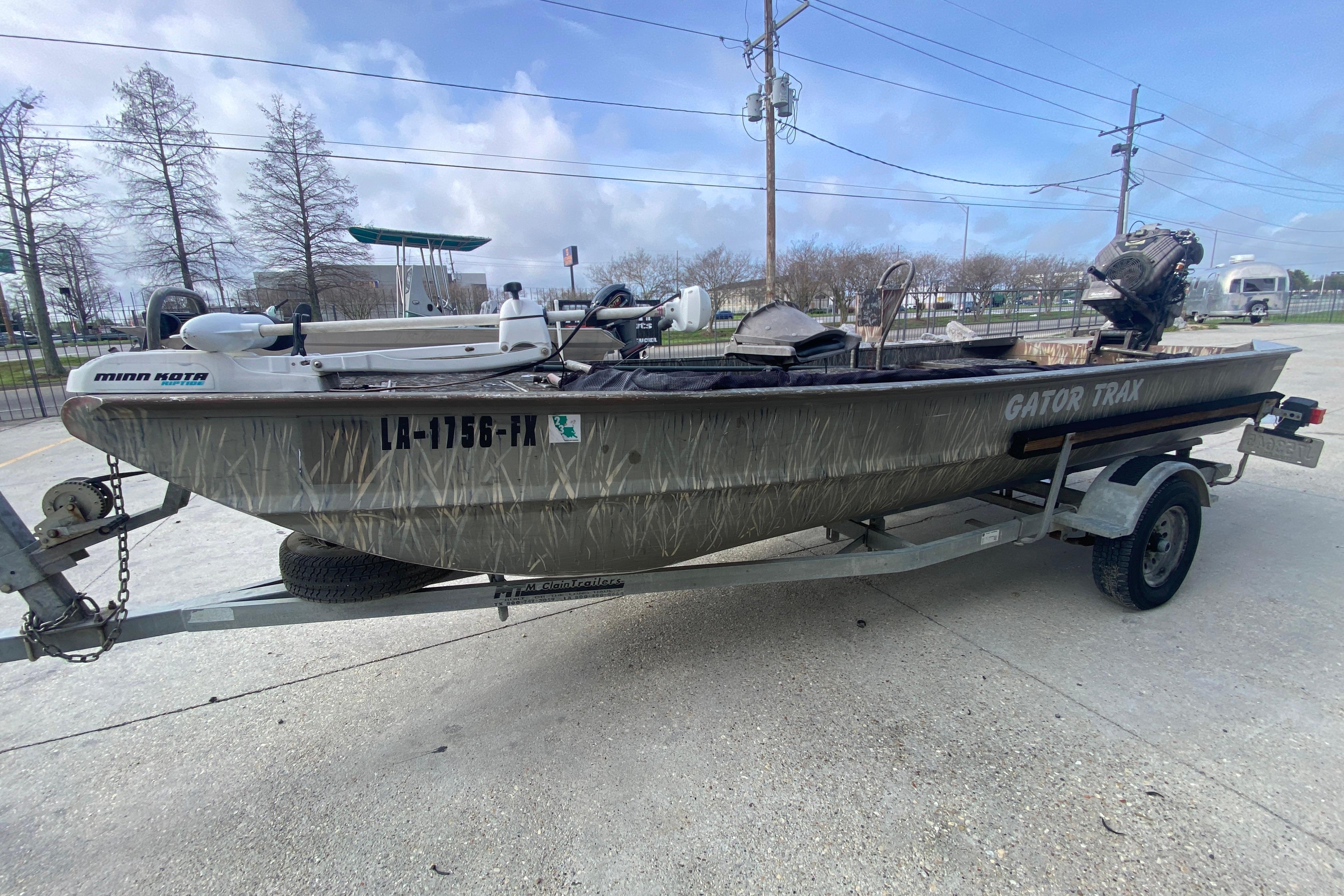 2009 Gator Trax MUD BUDDY boat on trailer, parked outdoors.