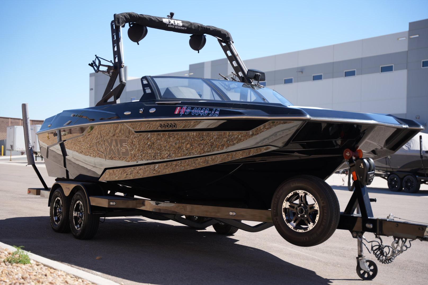 2019 Axis A22 boat on trailer, sleek black design, parked outdoors.