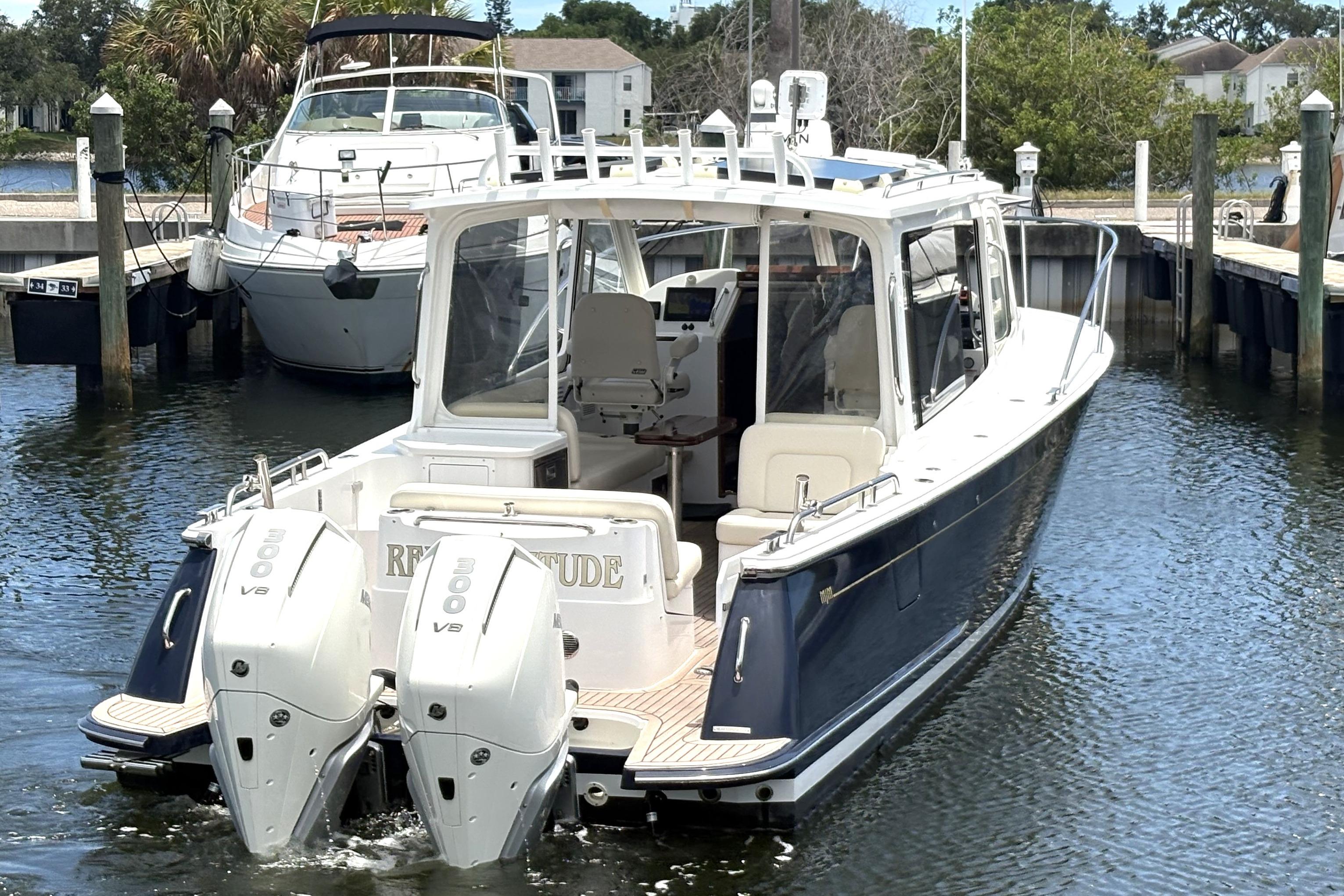 2024 MJM 35z boat docked with twin outboard engines in a marina setting.