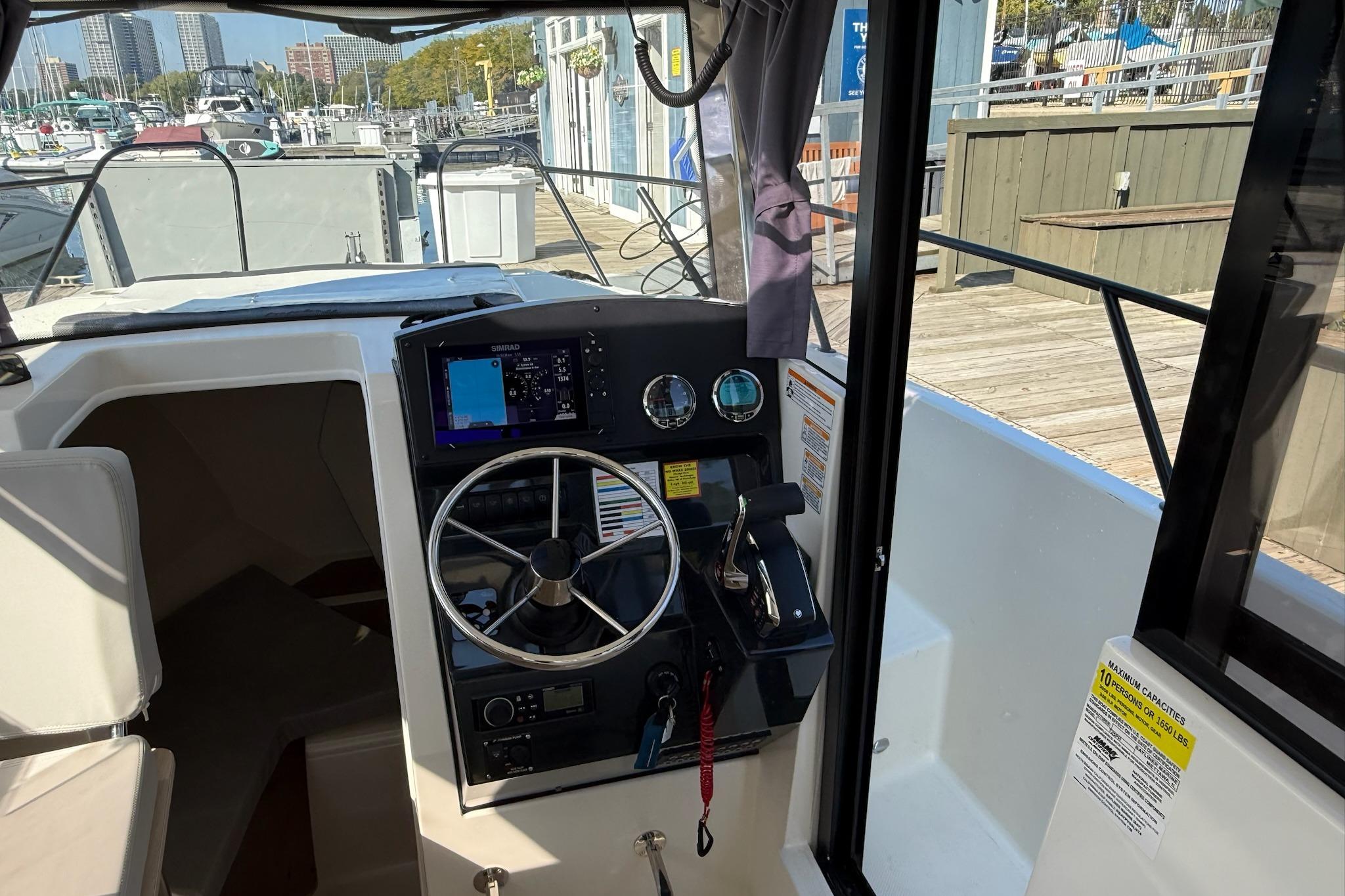 2024 Bayliner Trophy T25 Pilothouse helm with steering wheel and navigation controls.