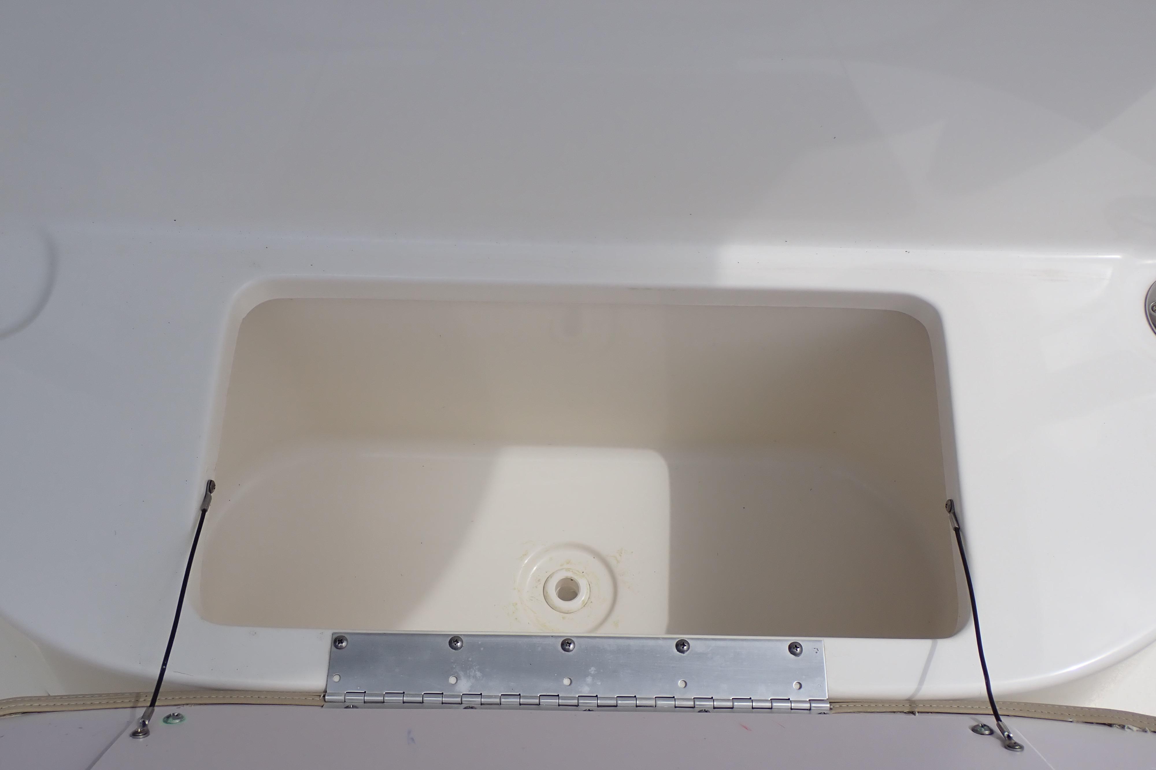 2019 Key West 263 FS boat storage compartment, open and empty, with metal hinge detail.