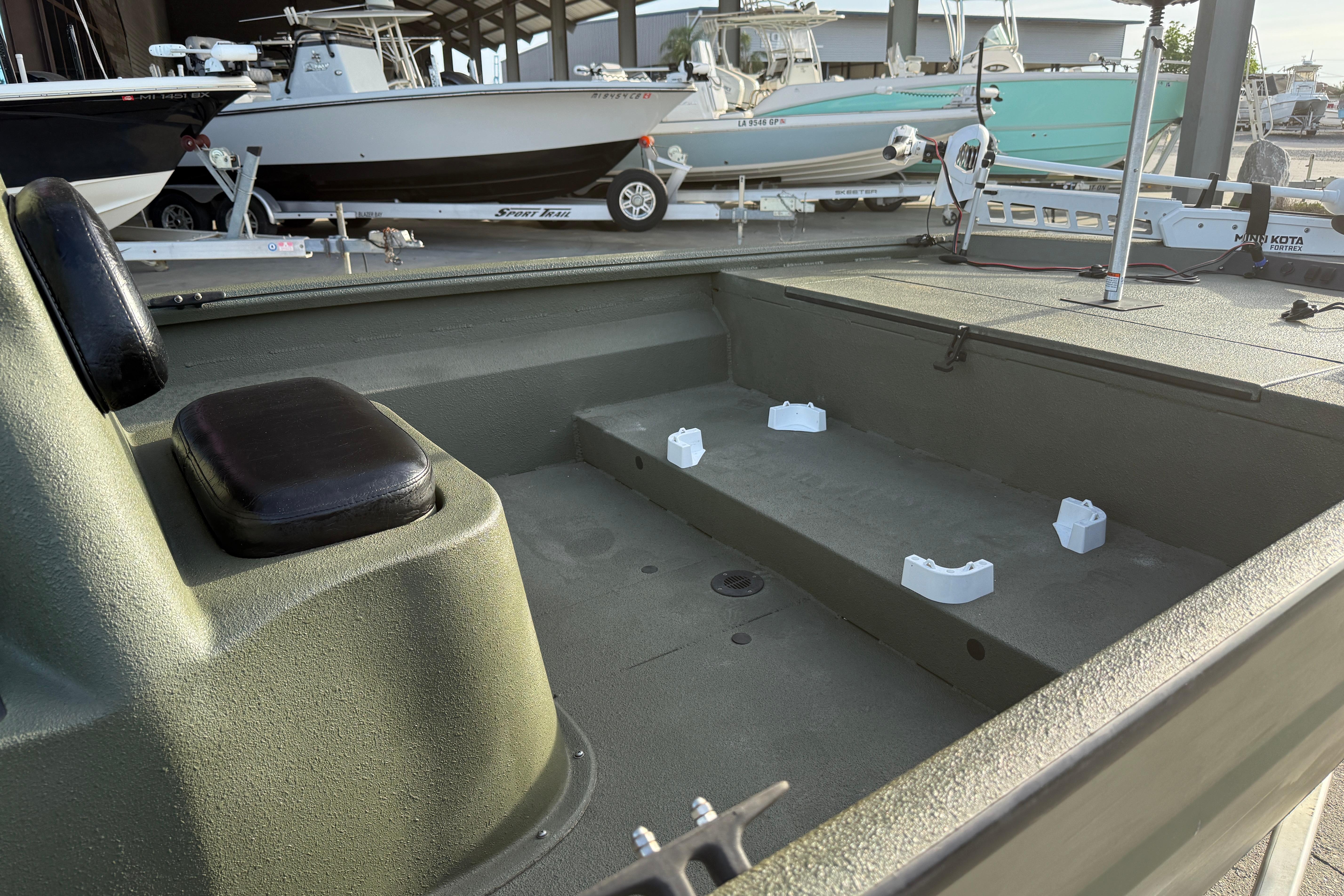2014 Excel 203 Bay Pro boat interior with seating and storage, docked alongside other boats.