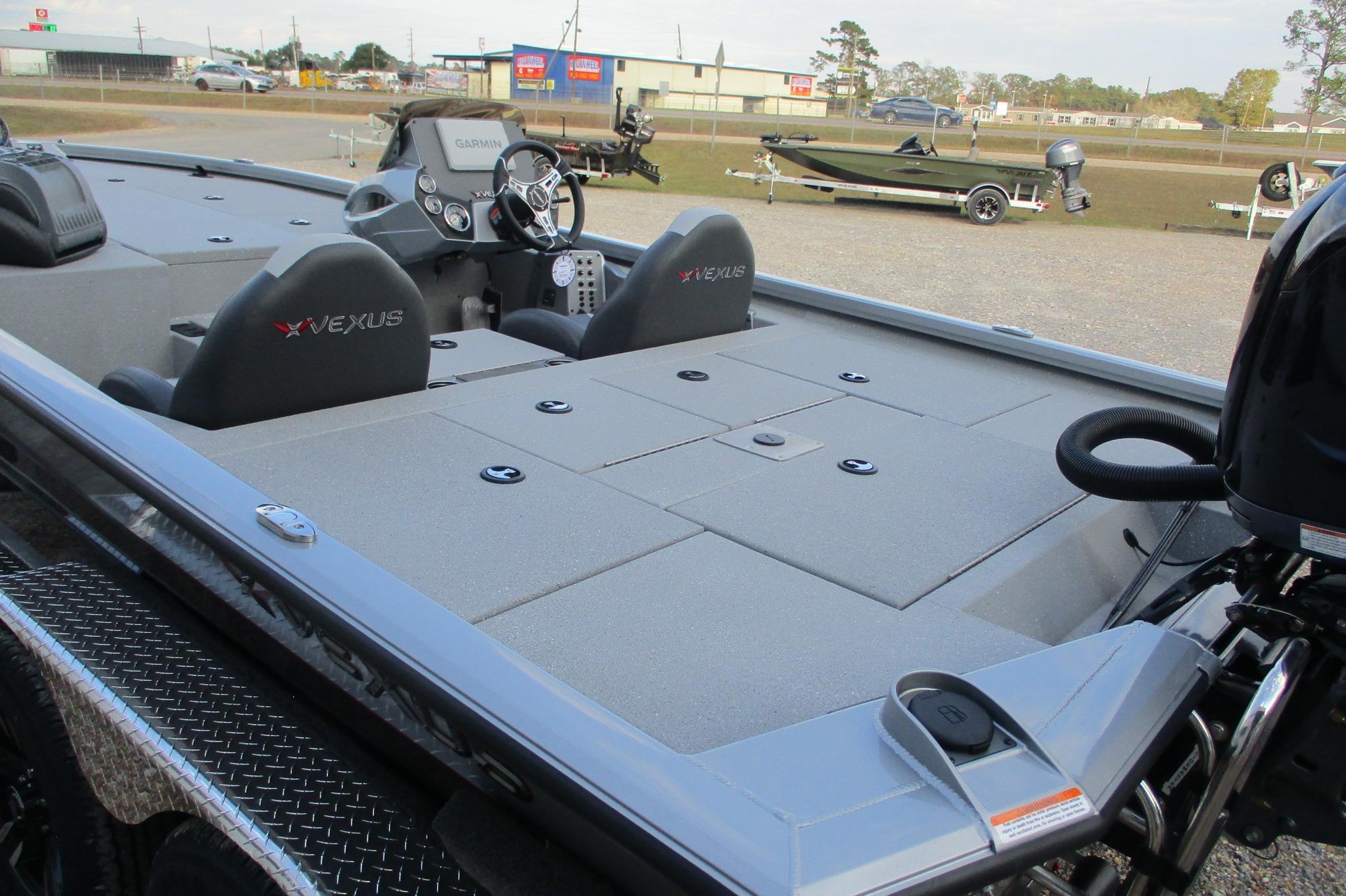2026 Vexus AVX2080 boat interior with steering wheel and seating, parked outdoors.