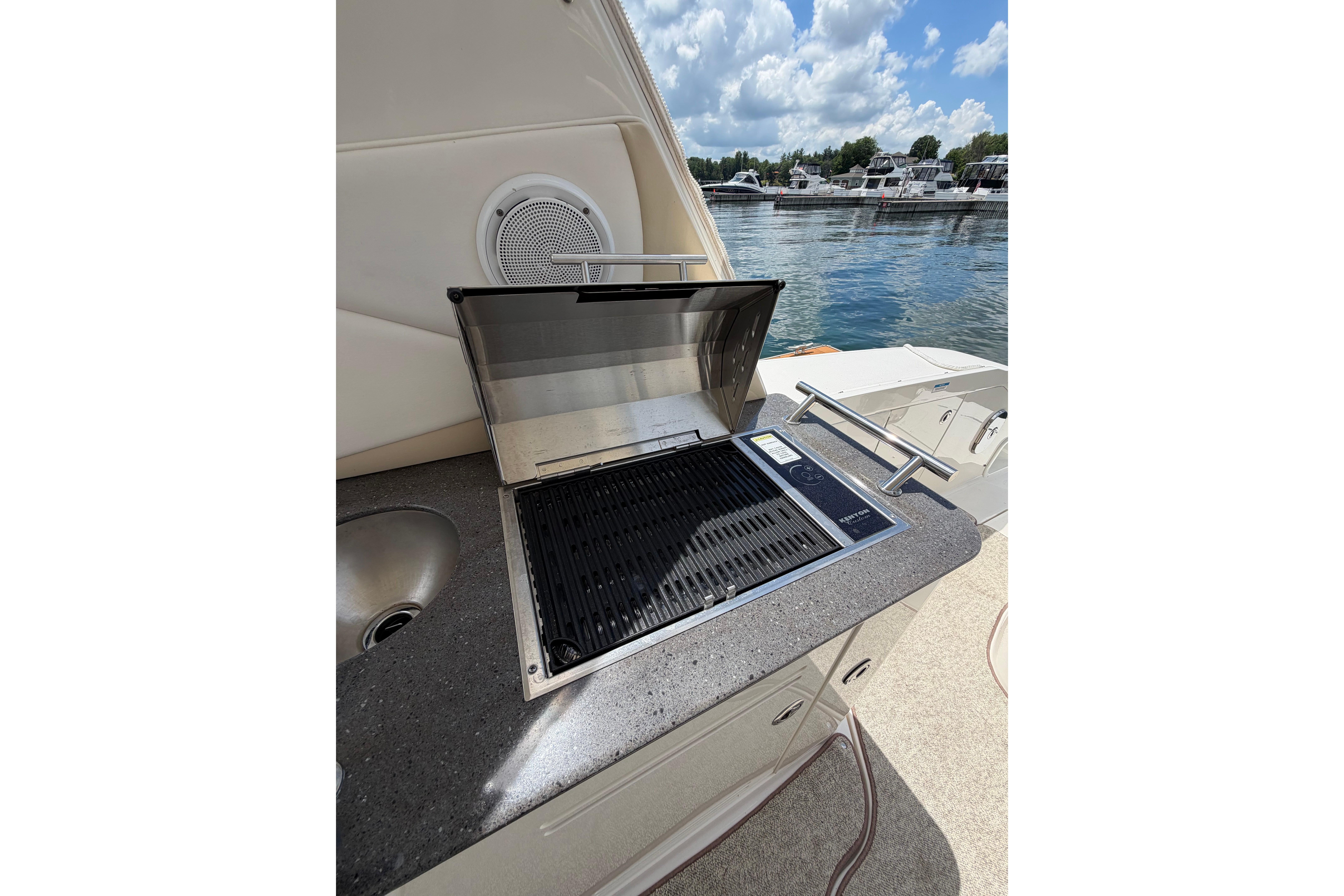 Outdoor grill on 2012 Sea Ray Sundancer 370 yacht, docked by the water.