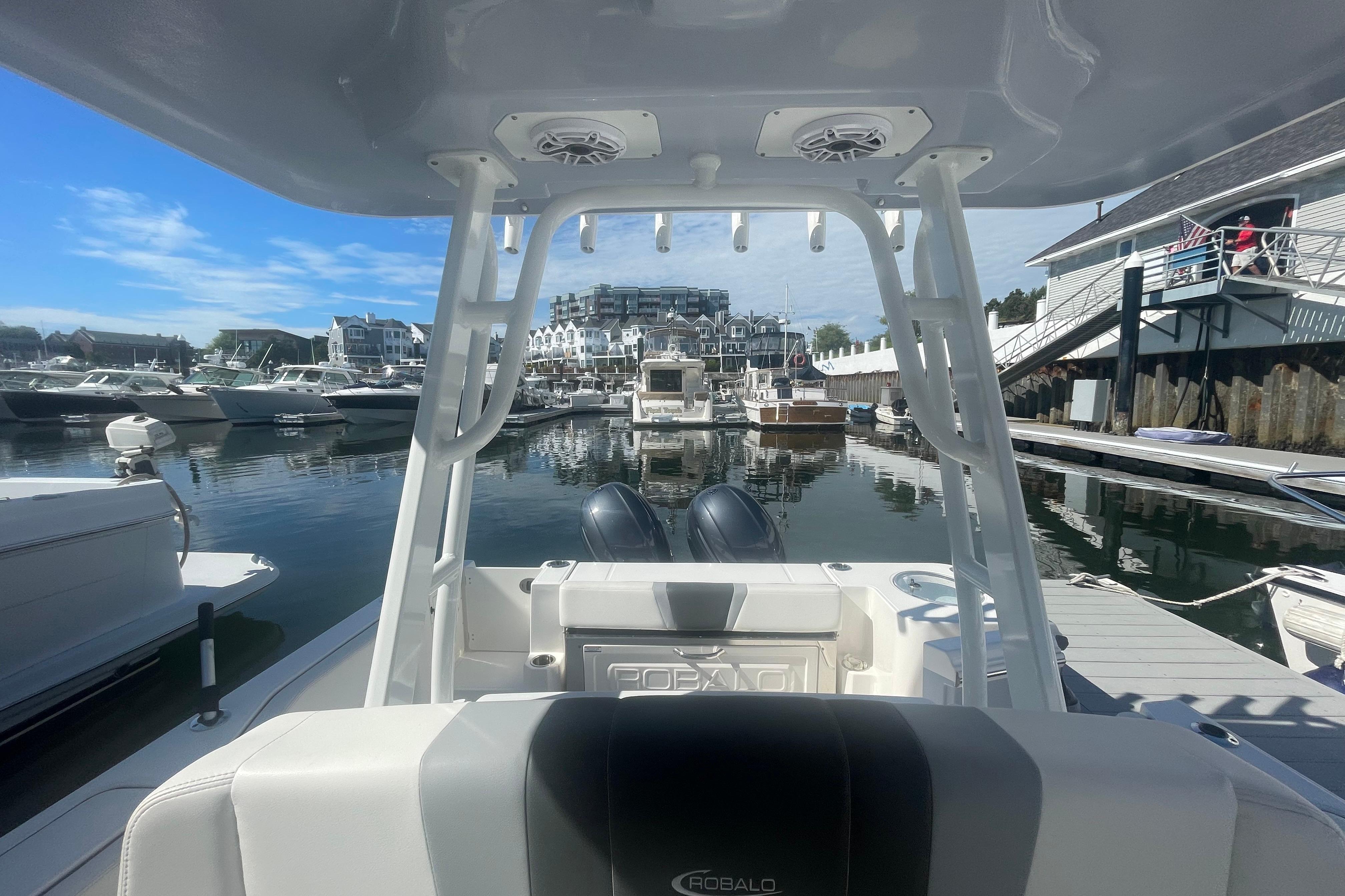 2023 Robalo R270 Center Console boat docked in a marina under clear blue skies.