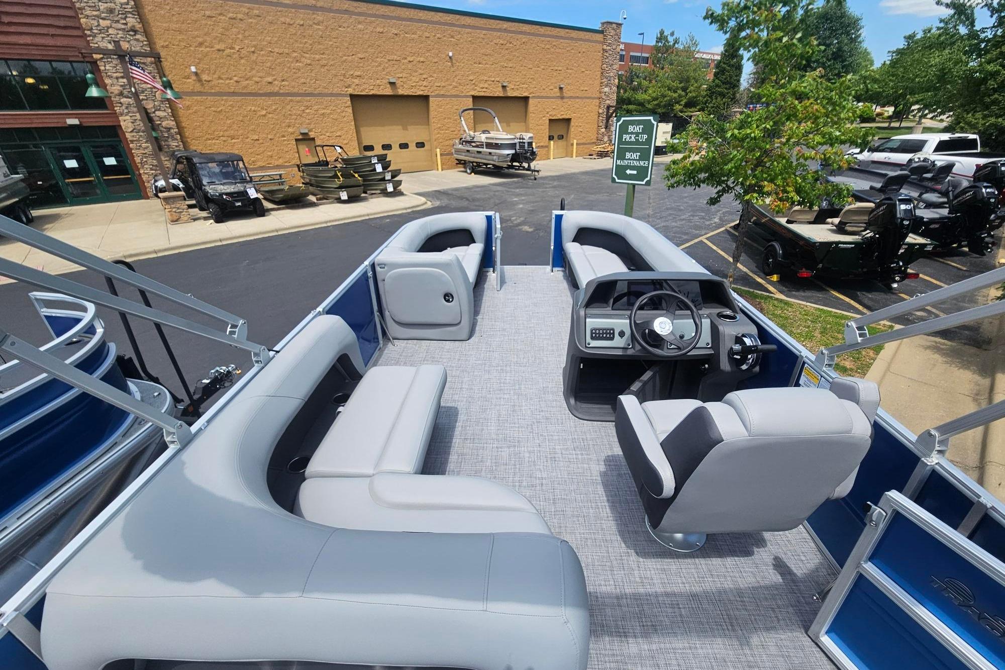 2026 Sun Tracker Party Barge 18 DLX pontoon boat interior with seating and steering console.