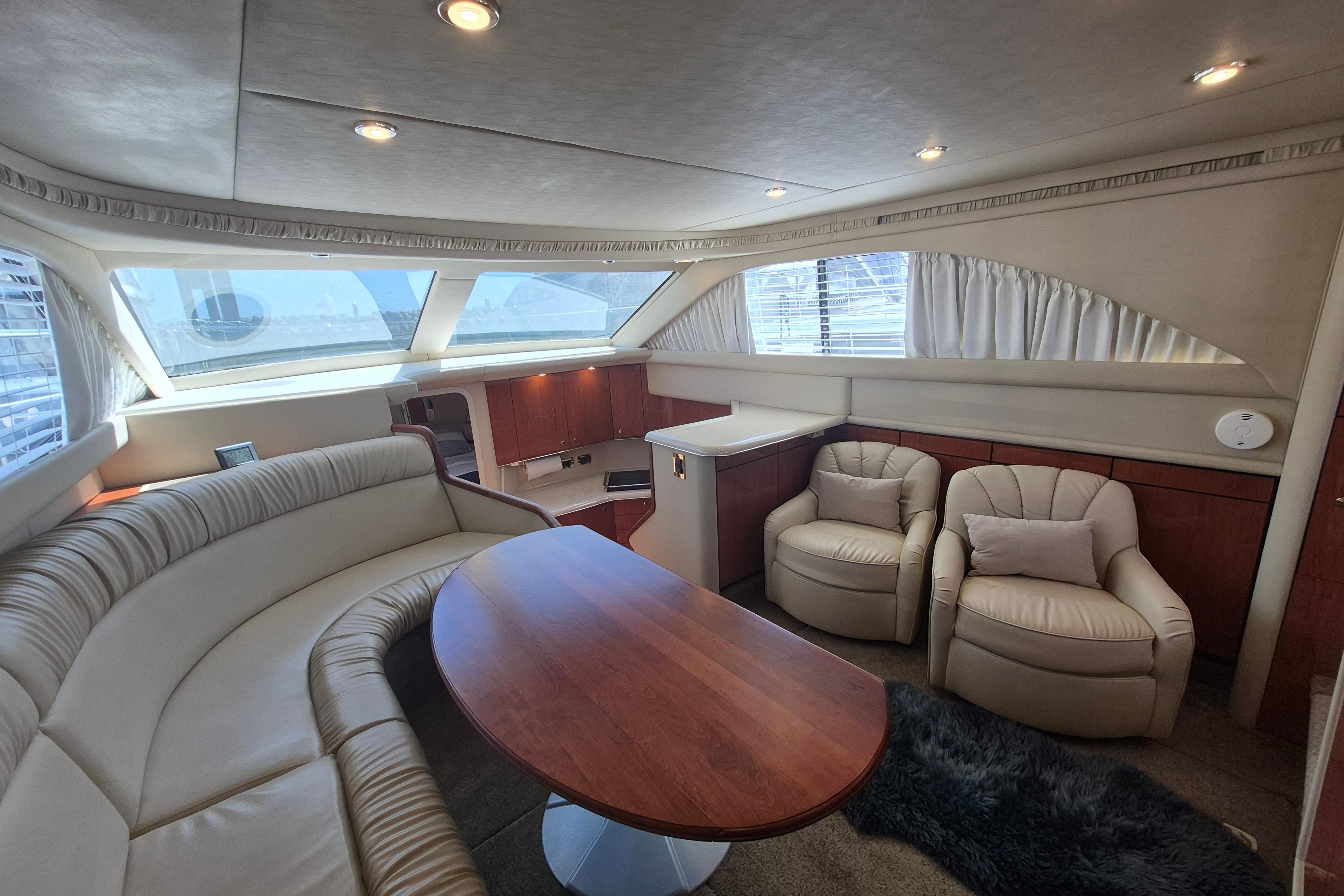 Luxurious interior of 2000 Sea Ray 380 Aft Cabin yacht with plush seating and wood accents.