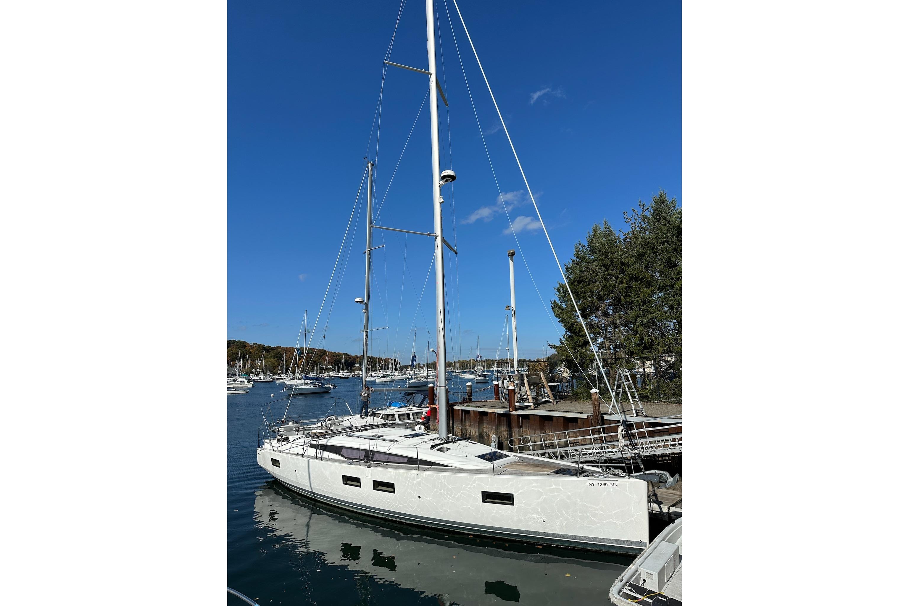 2018 Jeanneau 51 sailboat docked in a serene marina under a clear blue sky.