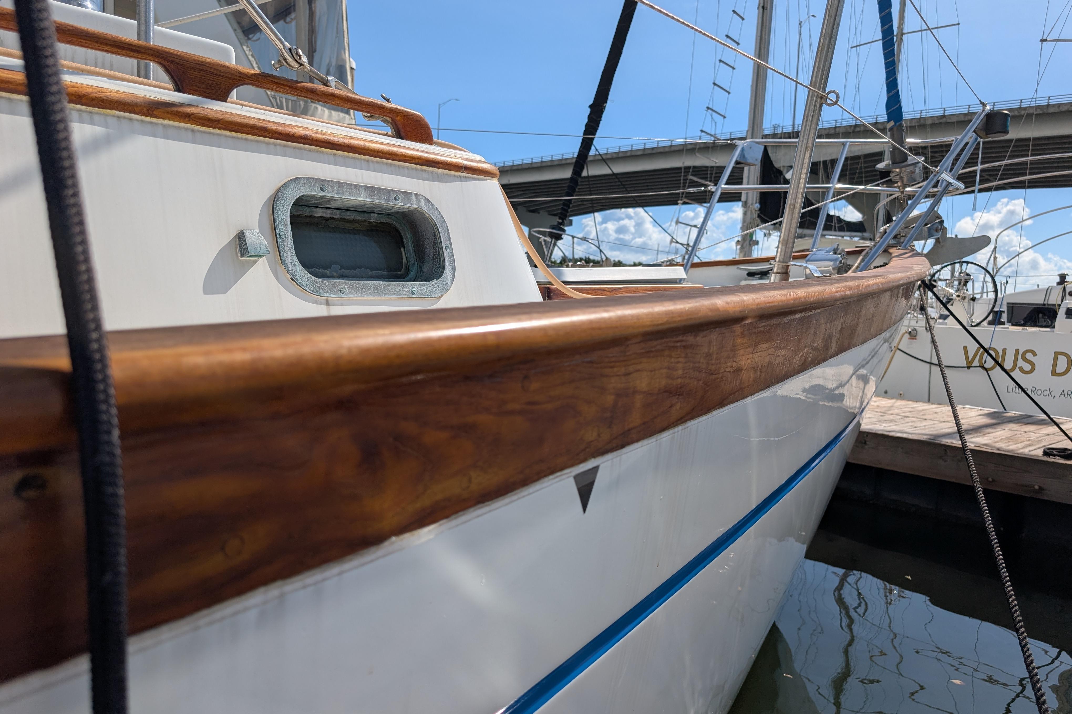 1983 Robert Perry 41 sailboat docked, showcasing polished wood and sleek design.