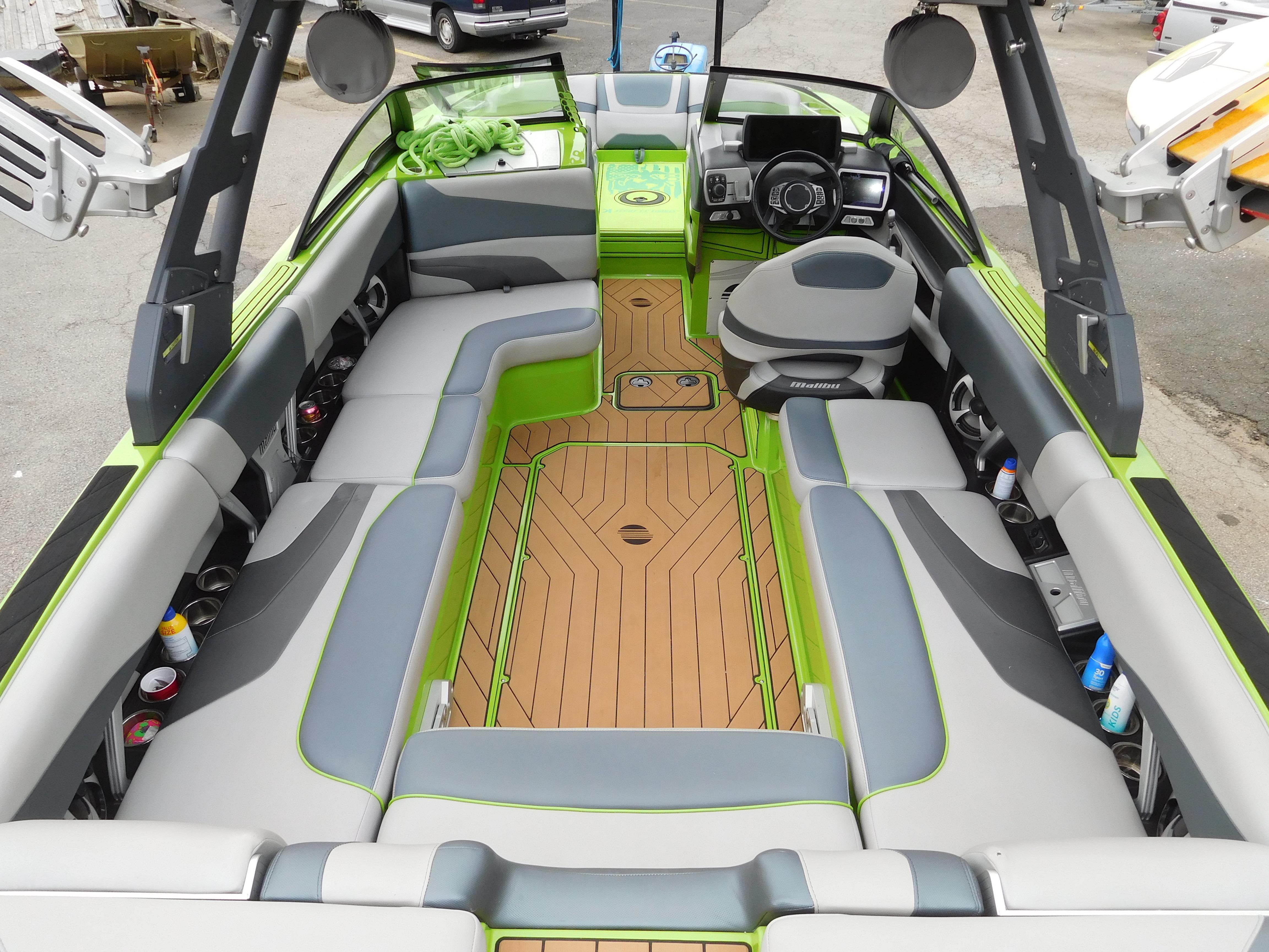 2017 Malibu Wakesetter 24 MXZ interior with green and gray seating, wood flooring.