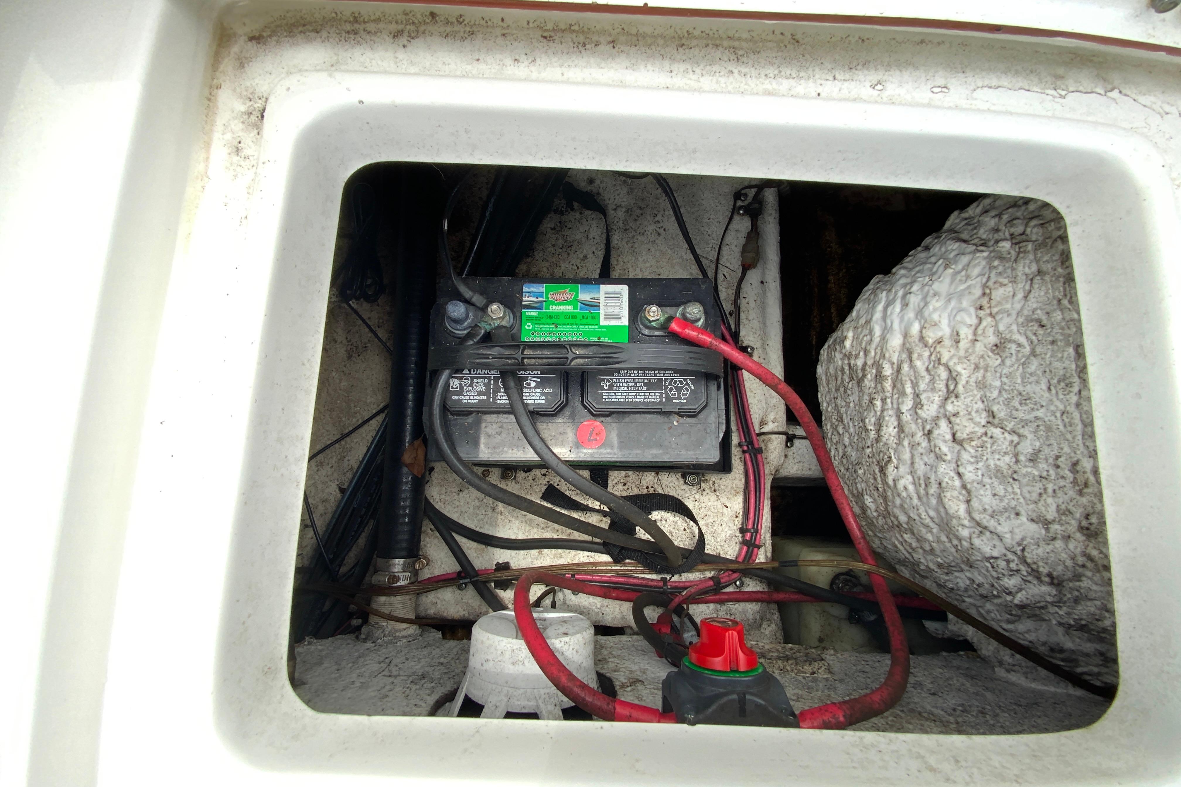 Battery compartment of a 2014 Sea Hunt Escape 211 LE boat, showing wiring and connections.