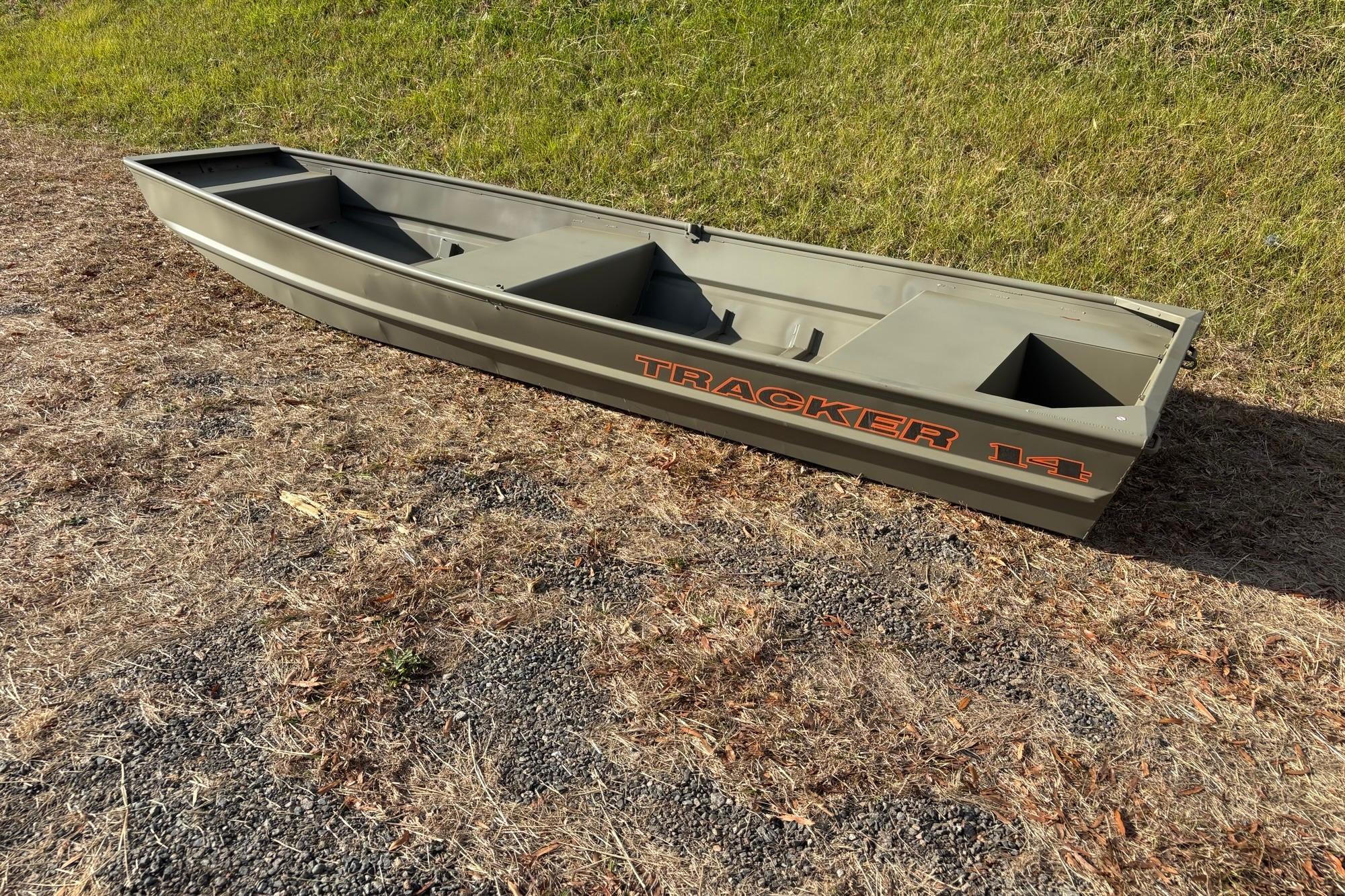 2026 Tracker Grizzly 14 Jon boat on dry grass, showcasing its sturdy design.